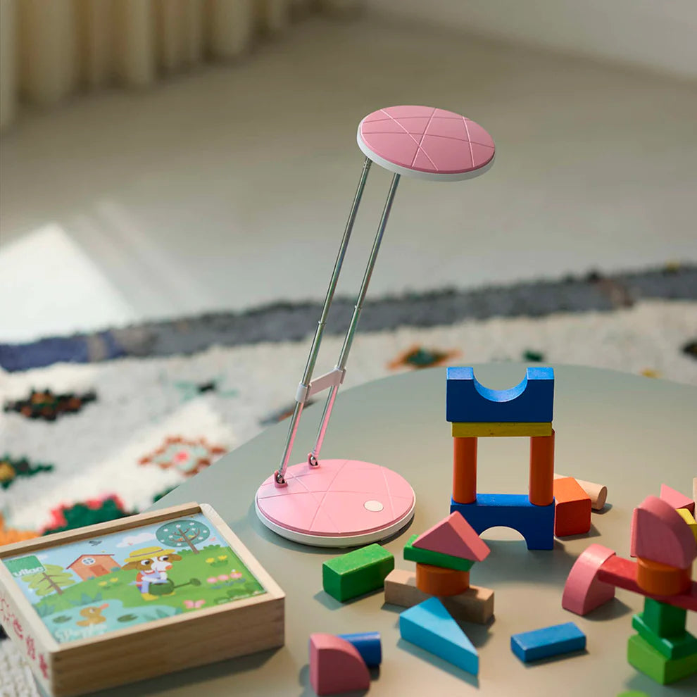 Den æstetiske A5 LED Bordlampe i Lyserød placeret på bordet i stuen for dens behagelige belysning