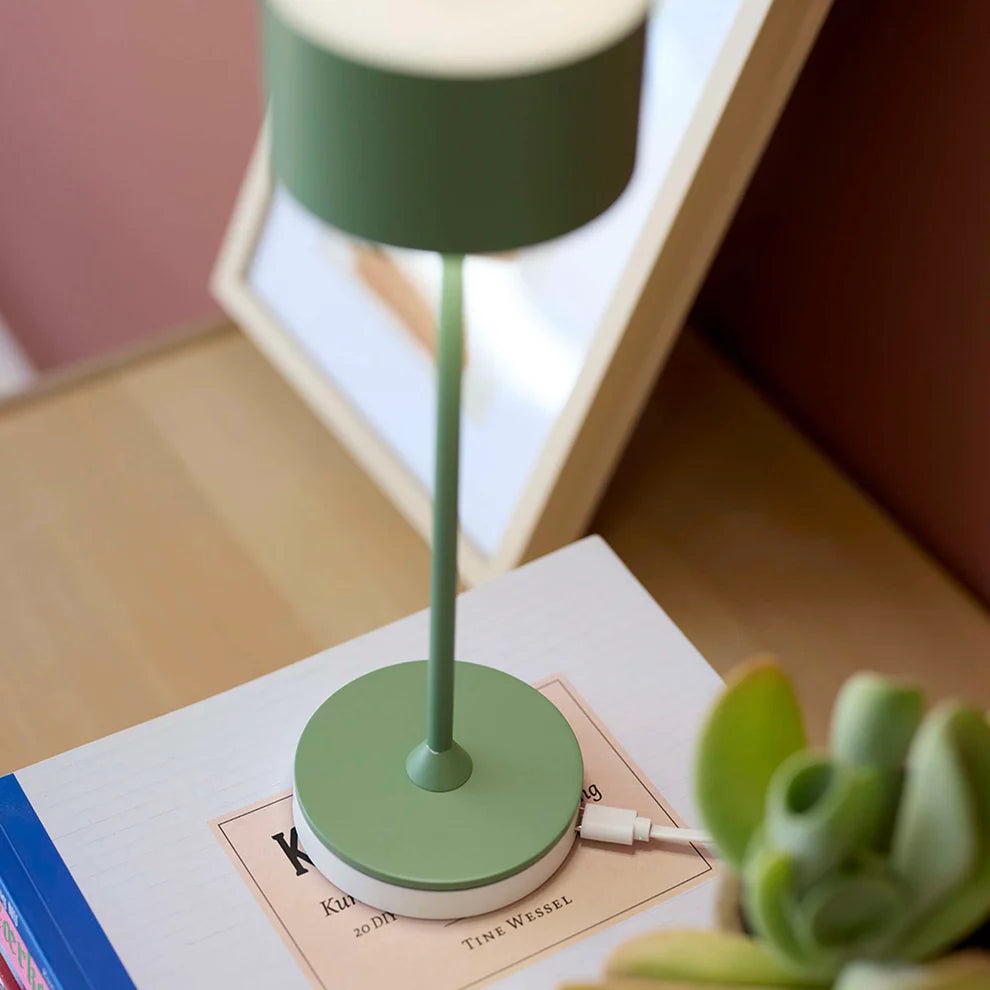 Zoomet ind på den elegante designet Bistro LED Bordlampe i Støvet Grøn med dens lade station under foden