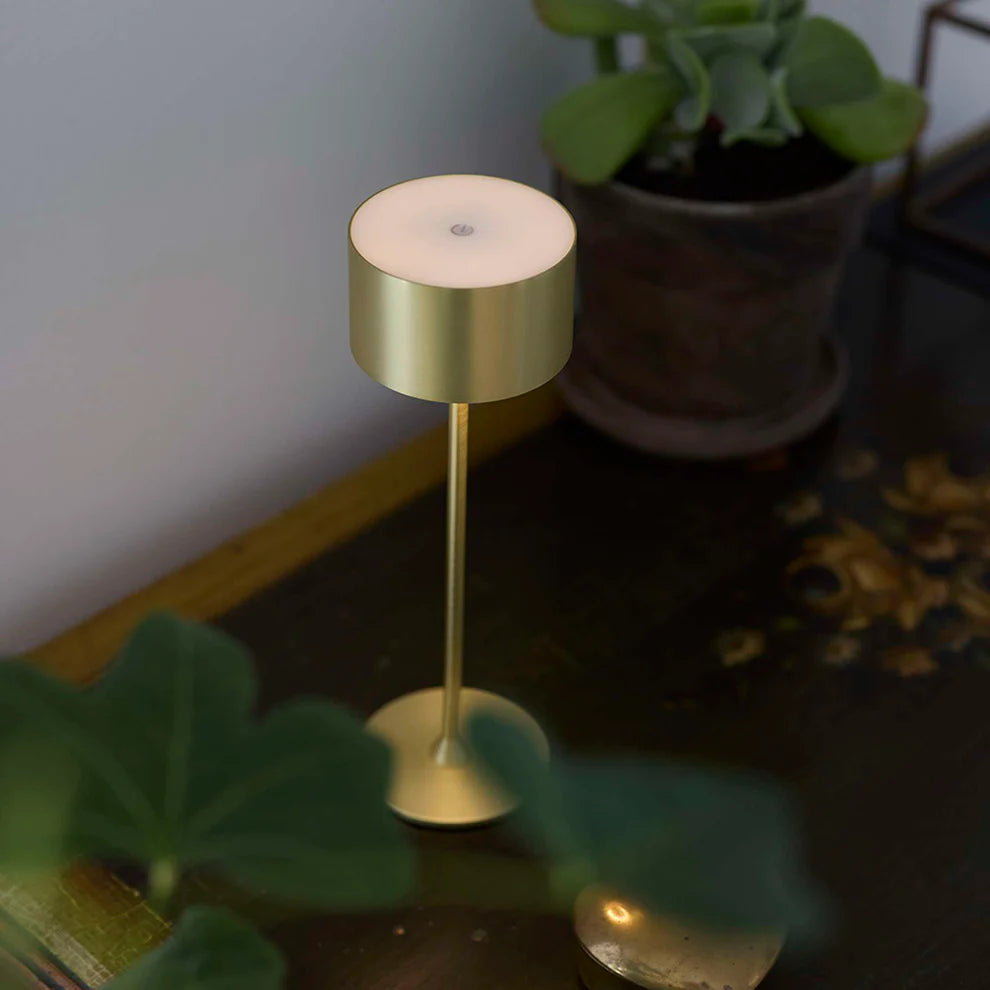 Den elegante Bistro LED Bordlampe i Børstet Messing placeret i stuen for dens unikke design i børstet messing