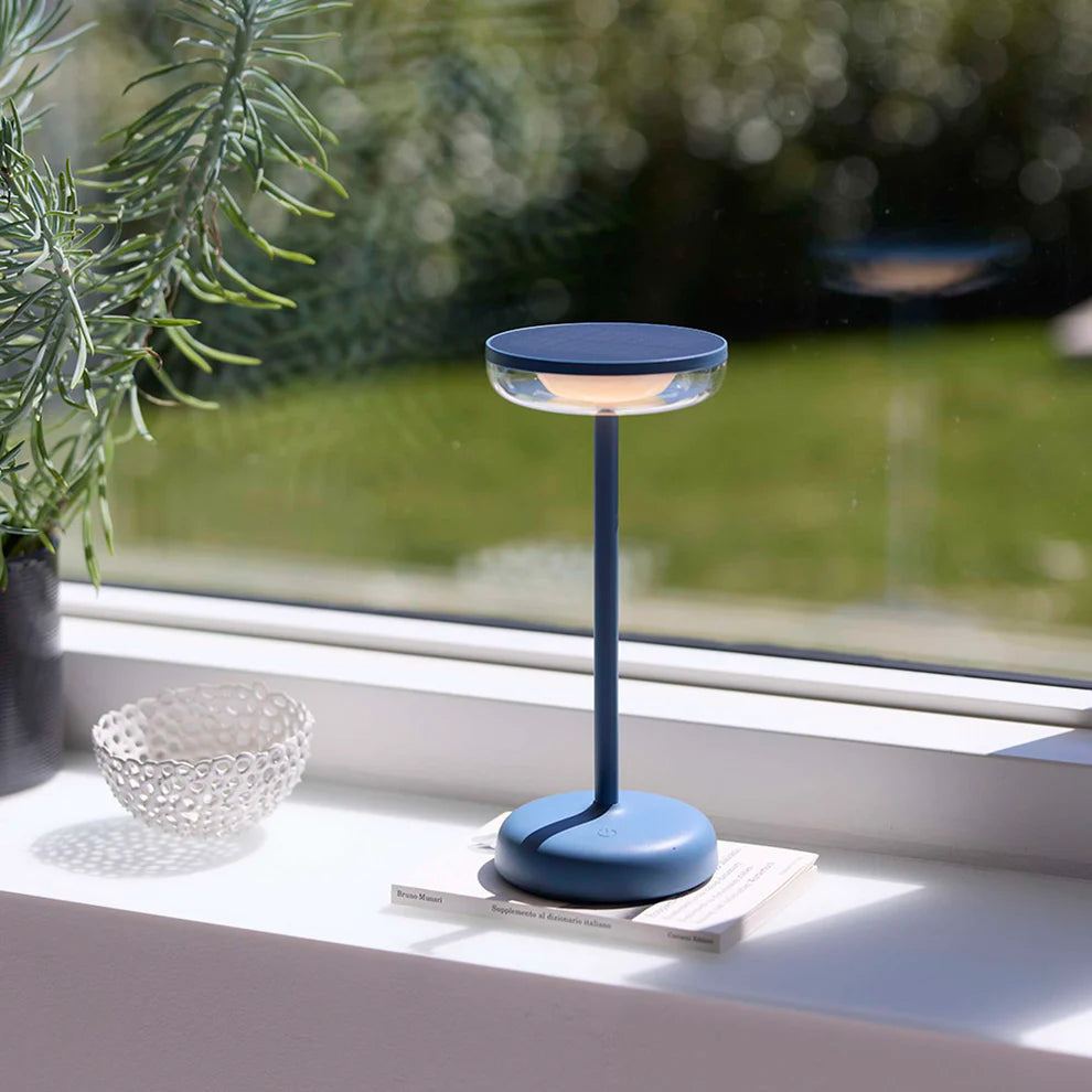 Den elegante designet Breeze LED Bordlampe i Støvet Blå placeret i stuen for dens behagelige belysning