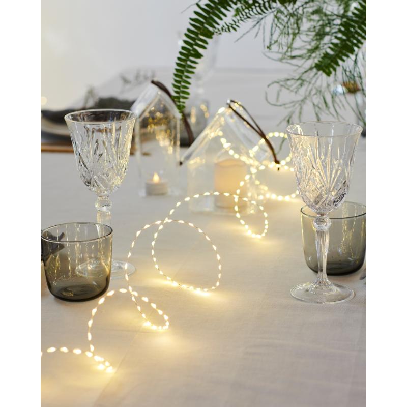 Den æstetiske Kiki 300 LED 4m i Guld placeret på spisebordet for dens behagelige belysning