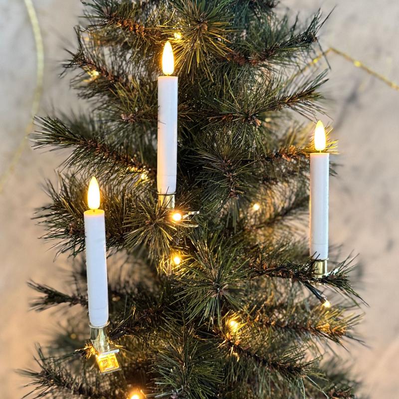 De æstetiske Sille Voks Juletræslys 10-Pak i Hvid placeret i et juletræ for deres behagelige belysning