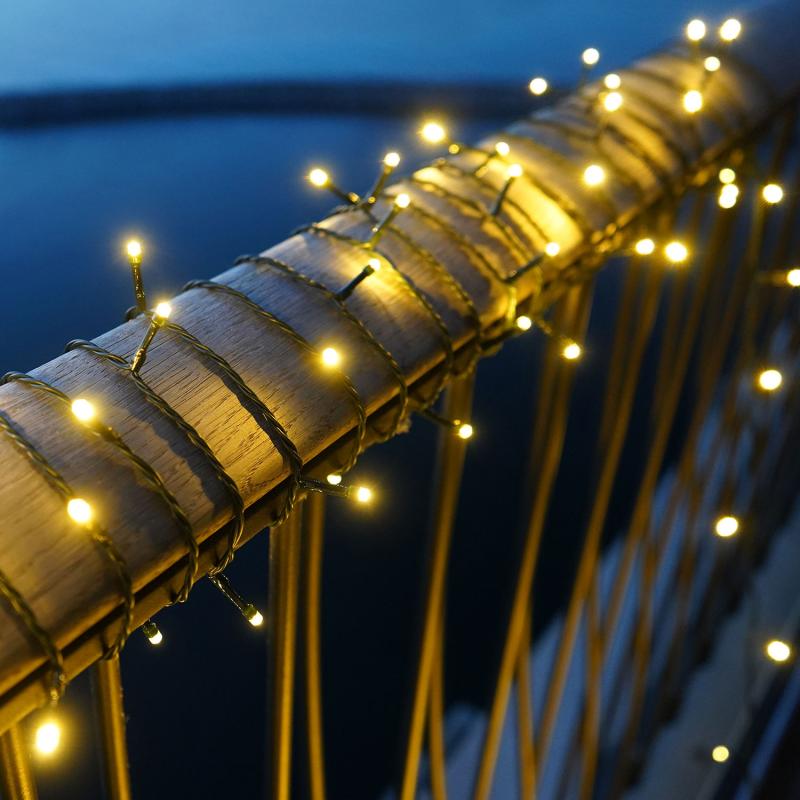 Den elegante Easy-Line Batterikæde 100 LED 9,9m i Grøn placeret udenfor for dens behagelige belysning