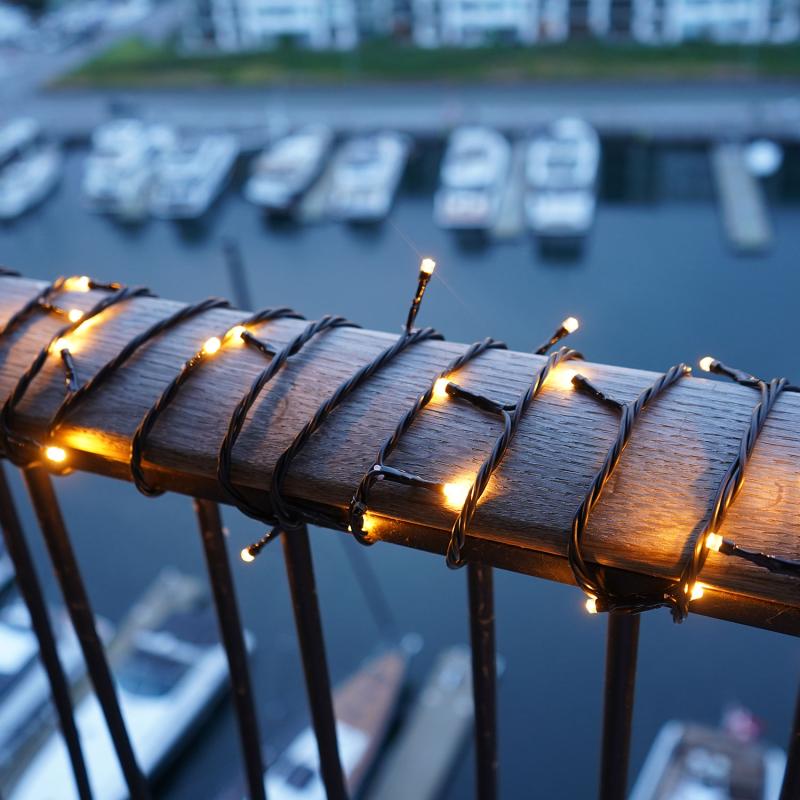 Den æstetiske Top-Line Energy Startsæt 50 LED 5m i Sort placeret på gelænderet for dens hyggelige belysning