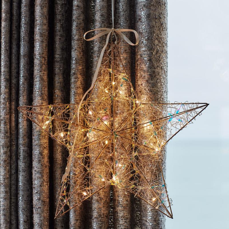 Den æstetiske Lily Stjerne 20 LED i Guld hængt op i stuen for dens behagelige belysning