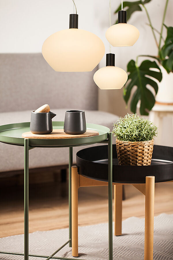 Den æstetiske Bell Pendel i Sort/Opal Hvid placeret over sofabordet i stuen