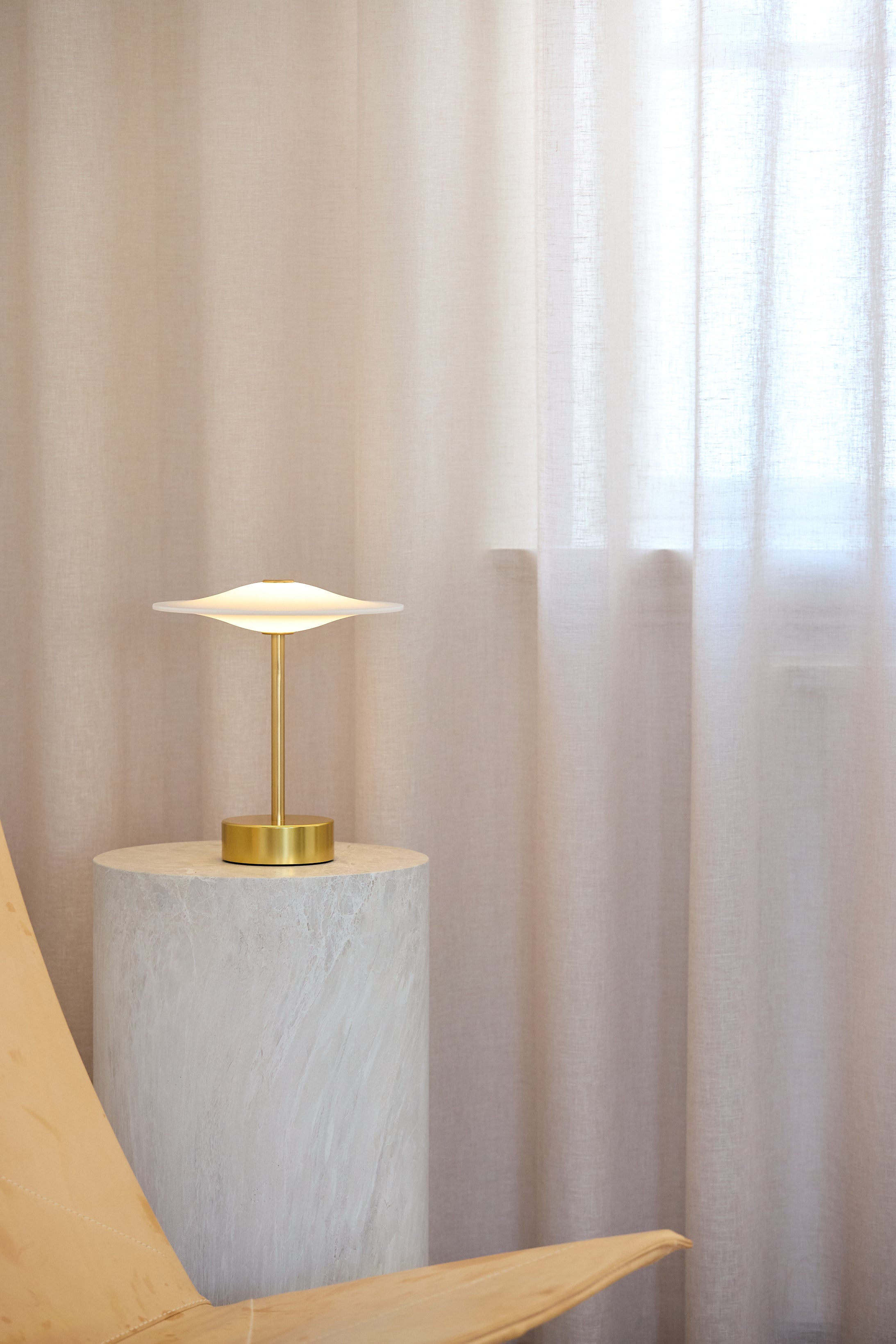 Den unikke designet Piet Hein Sinus22 Bordlampe i Messing placeret i hjørnet af stuen