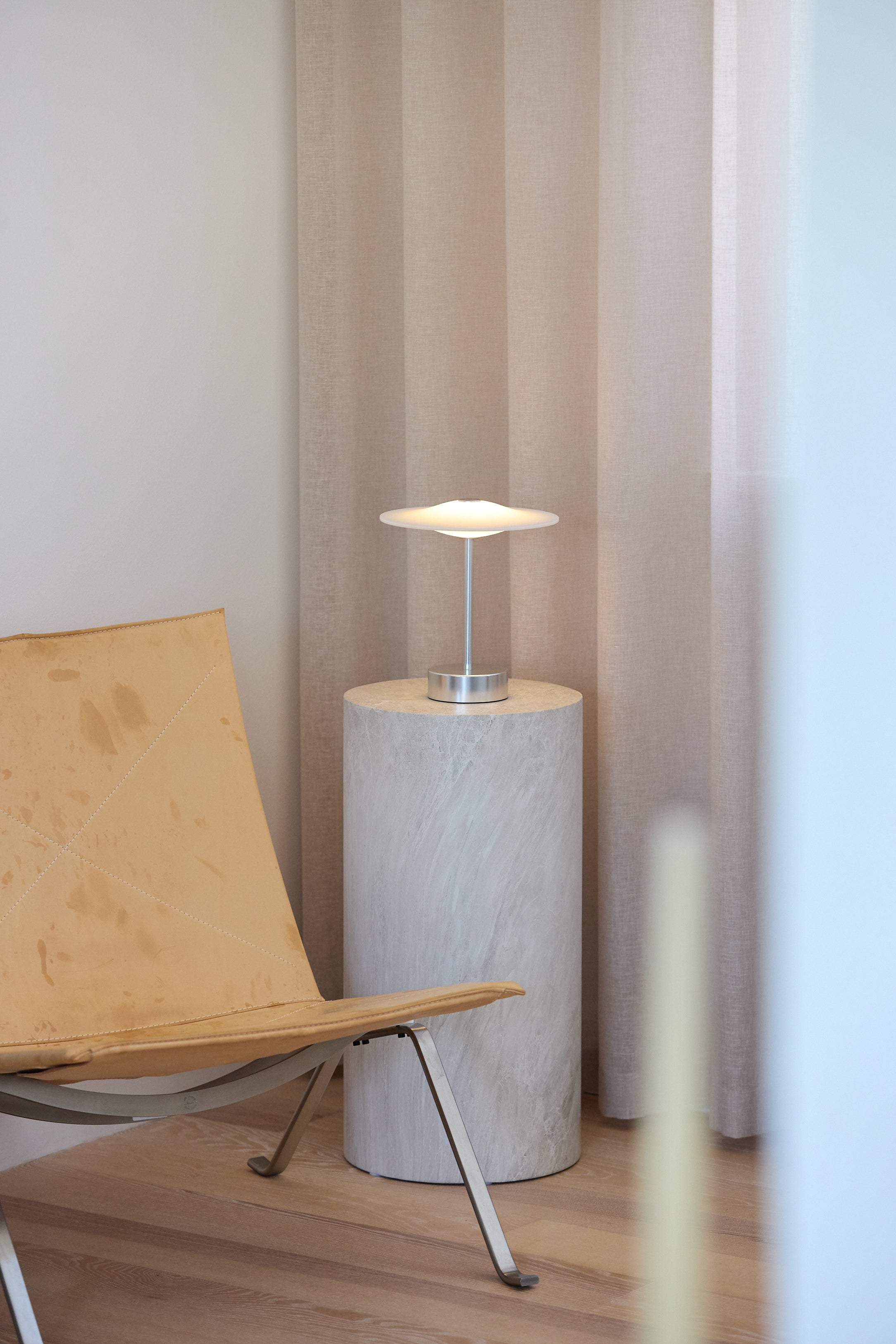 Piet Hein Sinus22 Bordlampe i Stål placeret i hjørnet af stuen for dens behagelige belysning