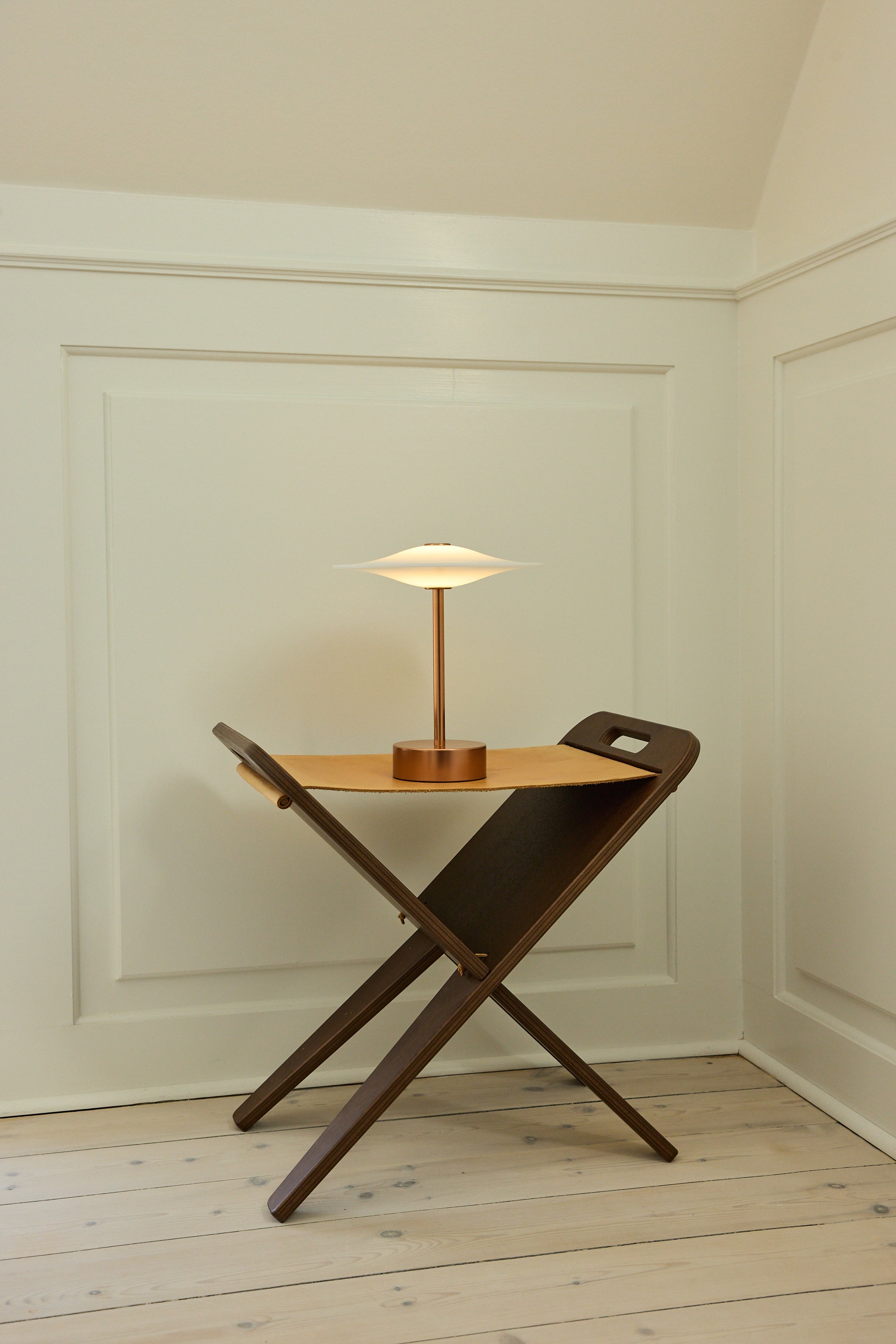 Den æstetiske Piet Hein Sinus22 Bordlampe i Kobber placeret i hjørnet af stuen