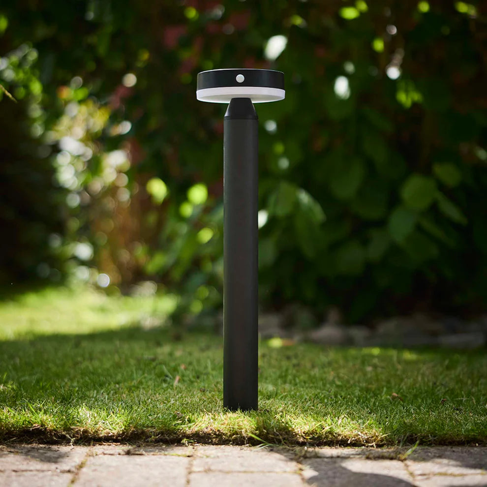 Den elegante designet Moonlight LED Solcelle Havelampe i Sort placeret udenfor på gågangen for dens varme belysning