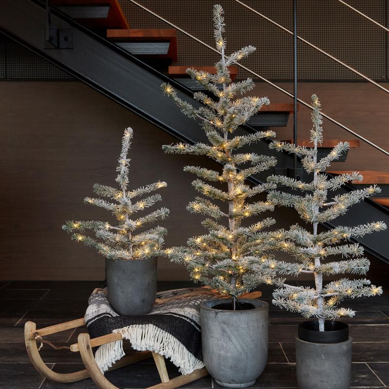 Den æstetiske Alfred Træ 1,2m 100 LED i Grøn/Sne placeret i stuen for dens unikke design og behagelige belysning