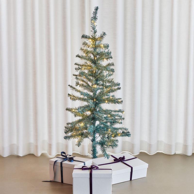 Den æstetiske Happy Juletræ 1,2m 60 LED i Grøn placeret i stuen for dens hyggelige belysning