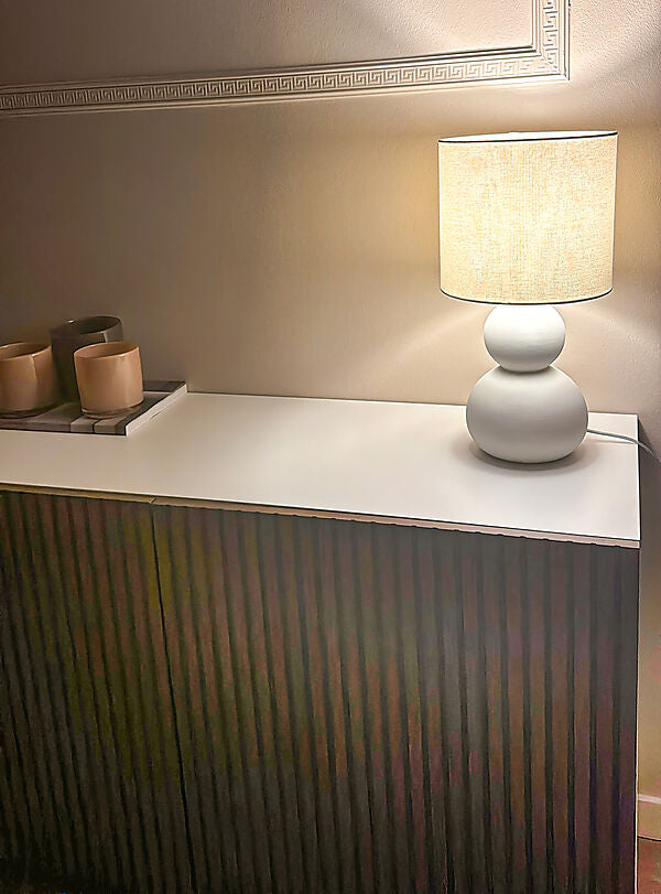 Den unikke designet Kalamata Bordlampe i Hvid placeret i stuen for dens behagelige belysning