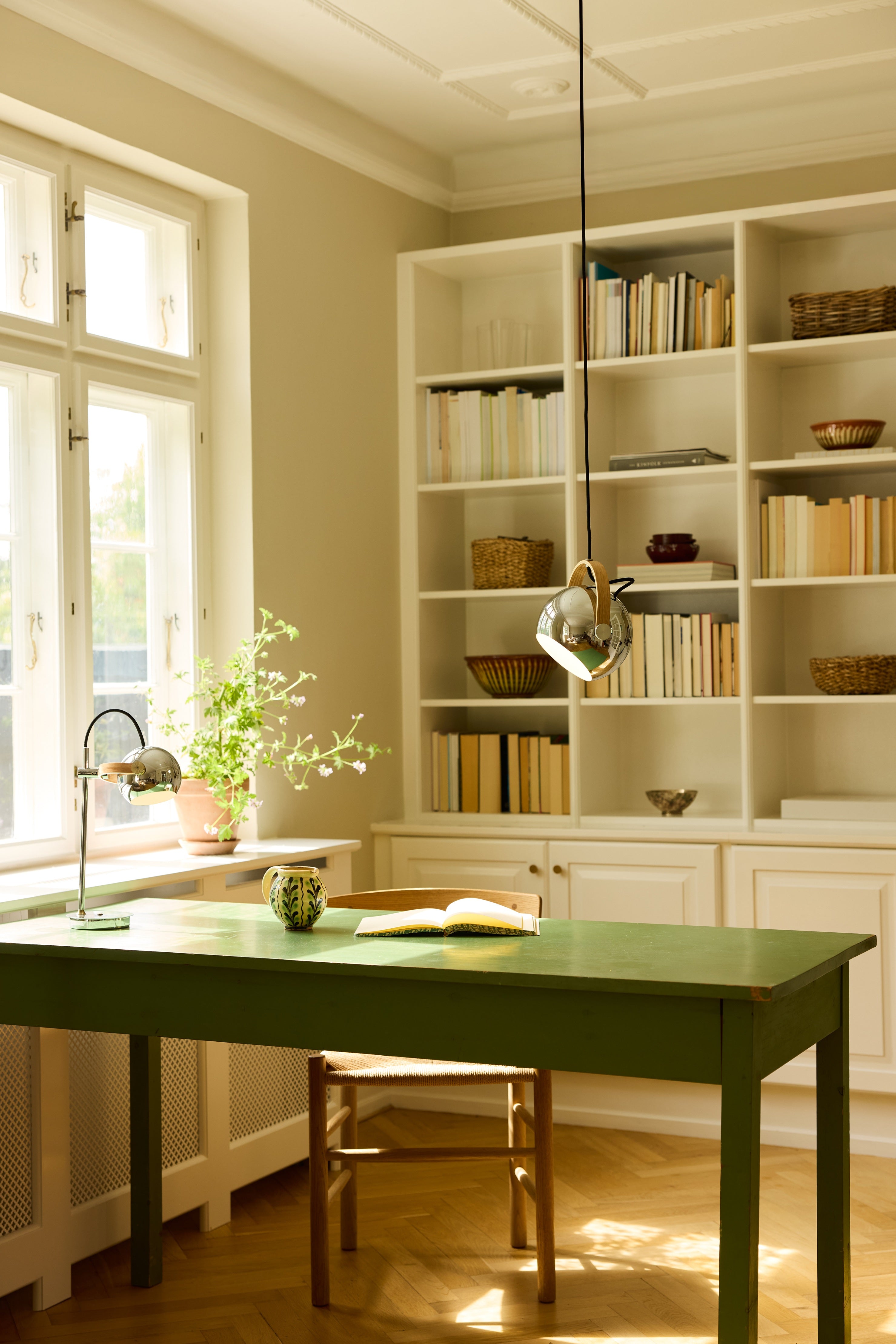 Den æstetiske DC Portable Bordlampe i Krom placeret på læsebordet i stuen for dens behagelige belysning