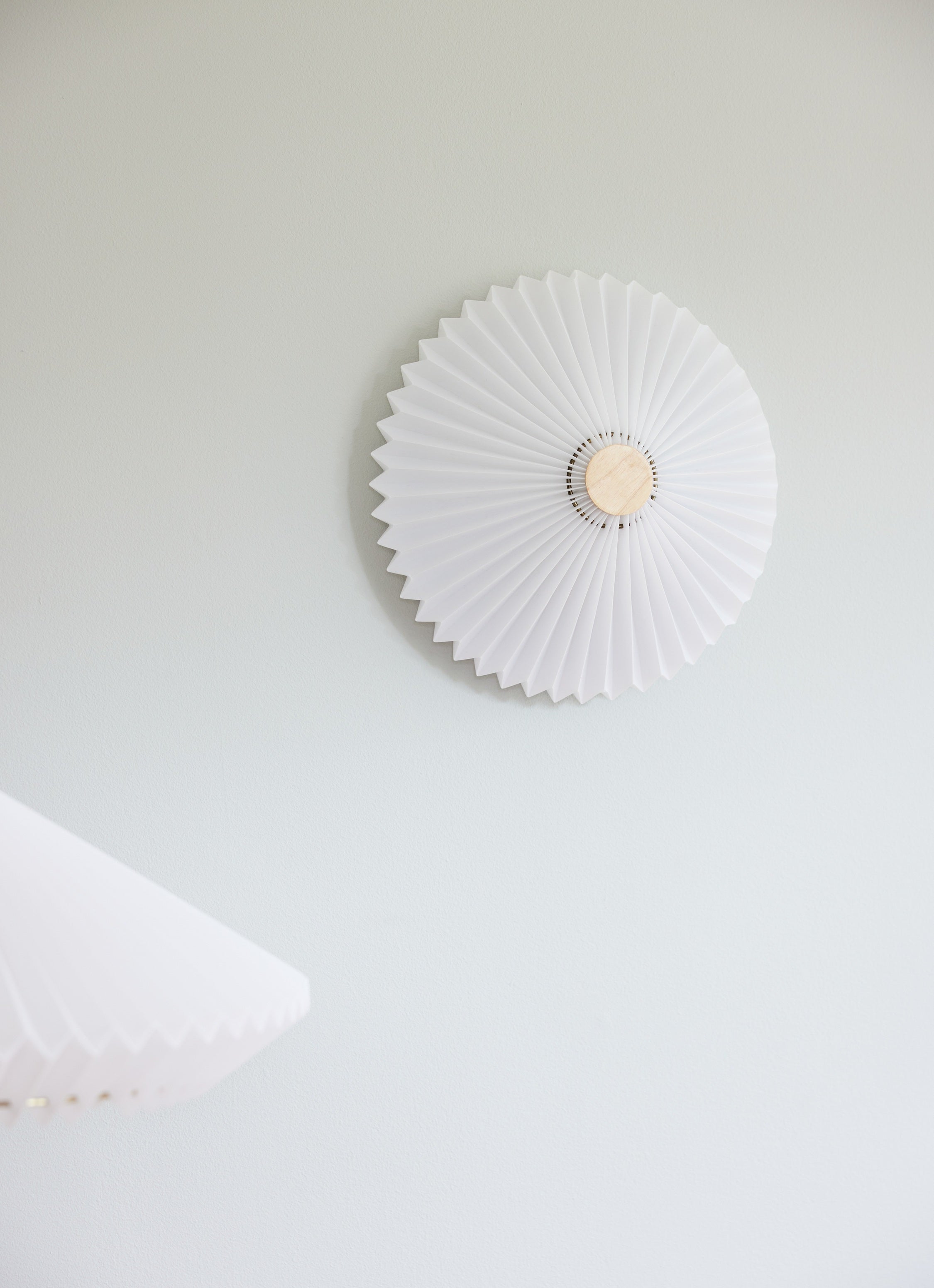 Zoomet ind på den unikke designet Paris Loft-Væglampe Ø50 i Hvid Antik hængt op af væggen for dens flotte kontrast