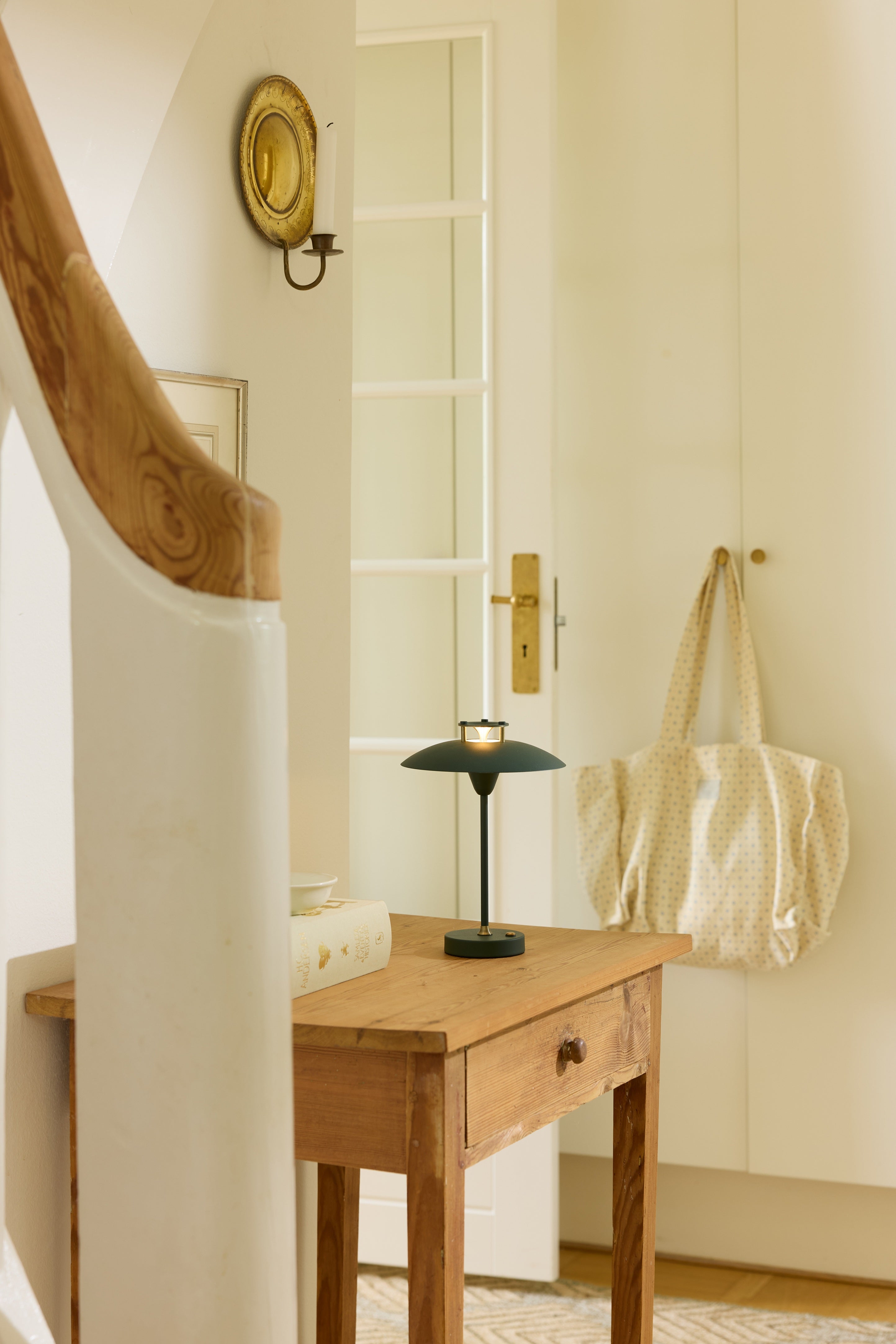 Den æstetiske Mini Stepp 1-2-3 Portable Bordlampe i Mørk Grøn placeret på en skuffe i stuen for dens behagelige belysning 