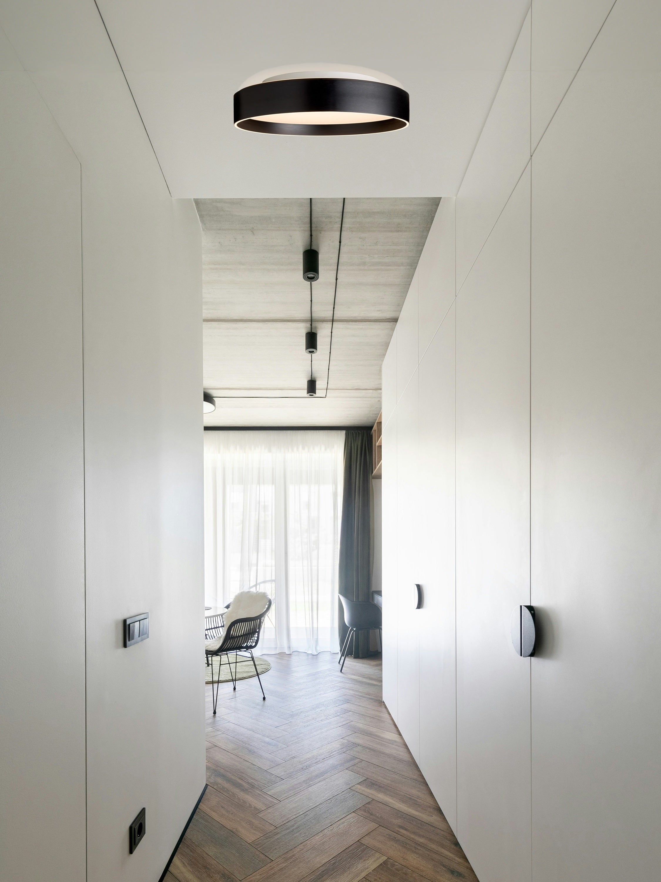 Den unikke og elegante designet Universal 3 Lite Loftslampe Ø50 i Sort hængt op i gangen for dens behagelige belysning