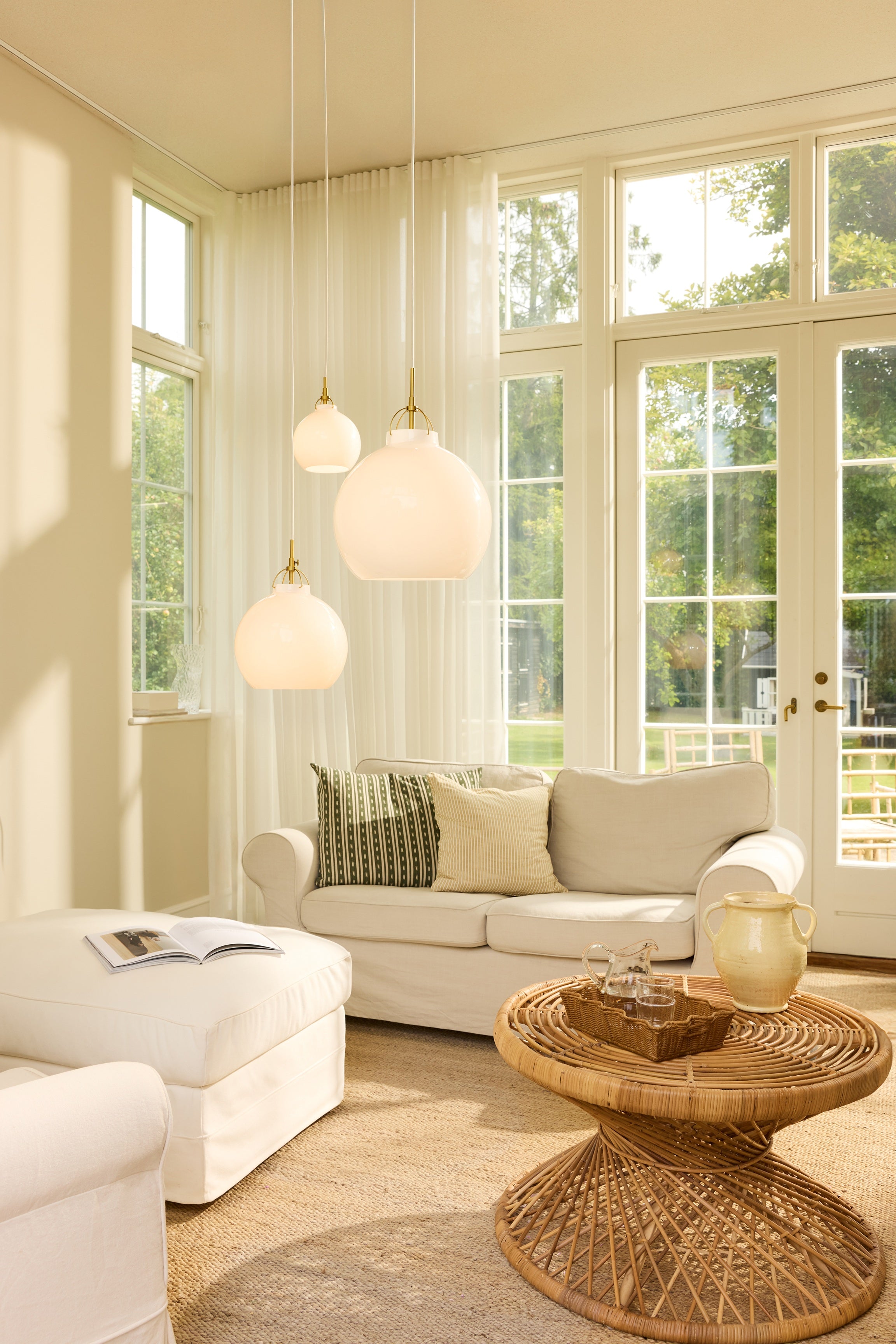 Den æstetiske Toscana Pendel Ø27 i Opal hængt op i stuen for dens behagelige belysning