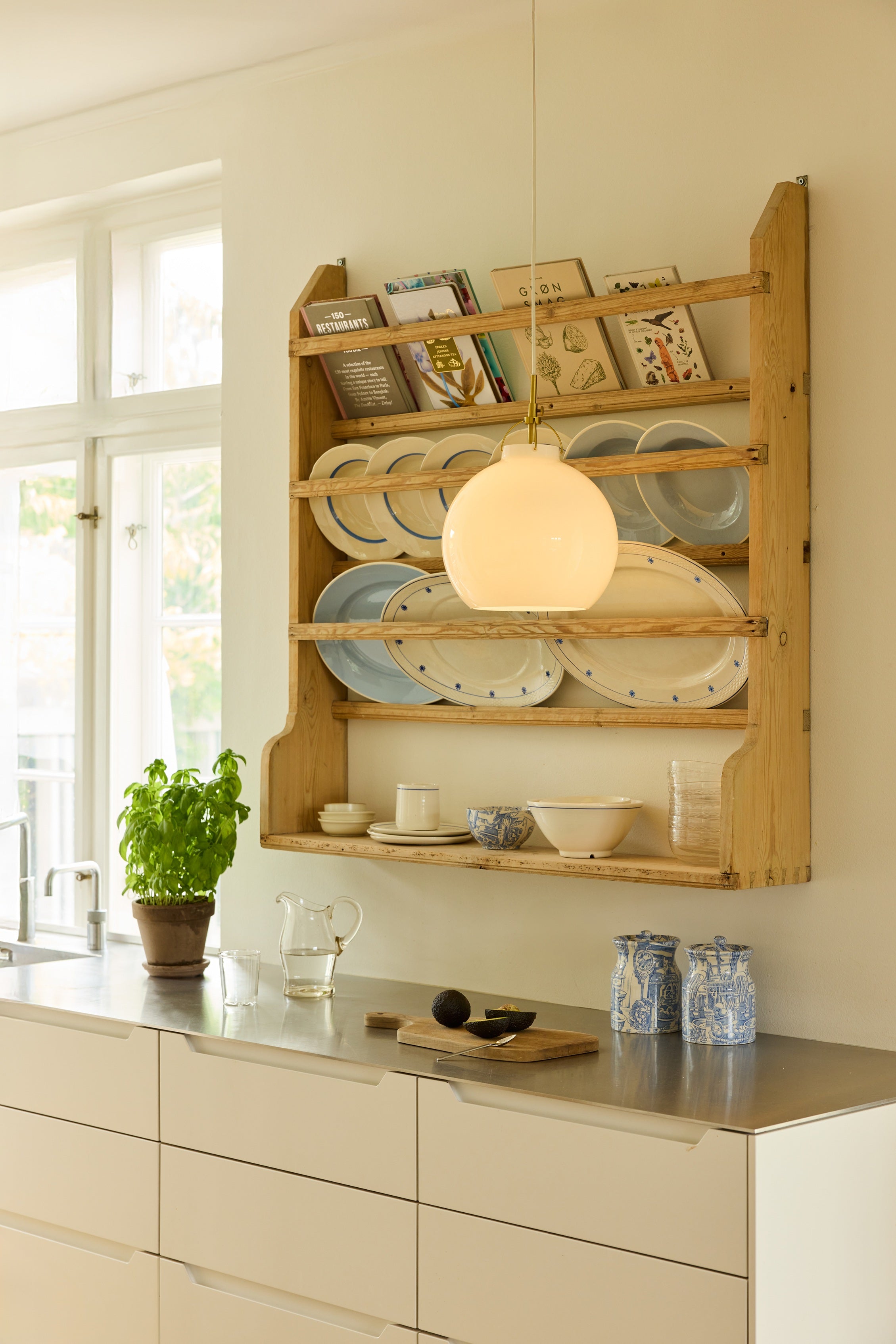 Den æstetiske Toscana Pendel Ø36 i Opal hængt op i køkkenet for dens varme belysning