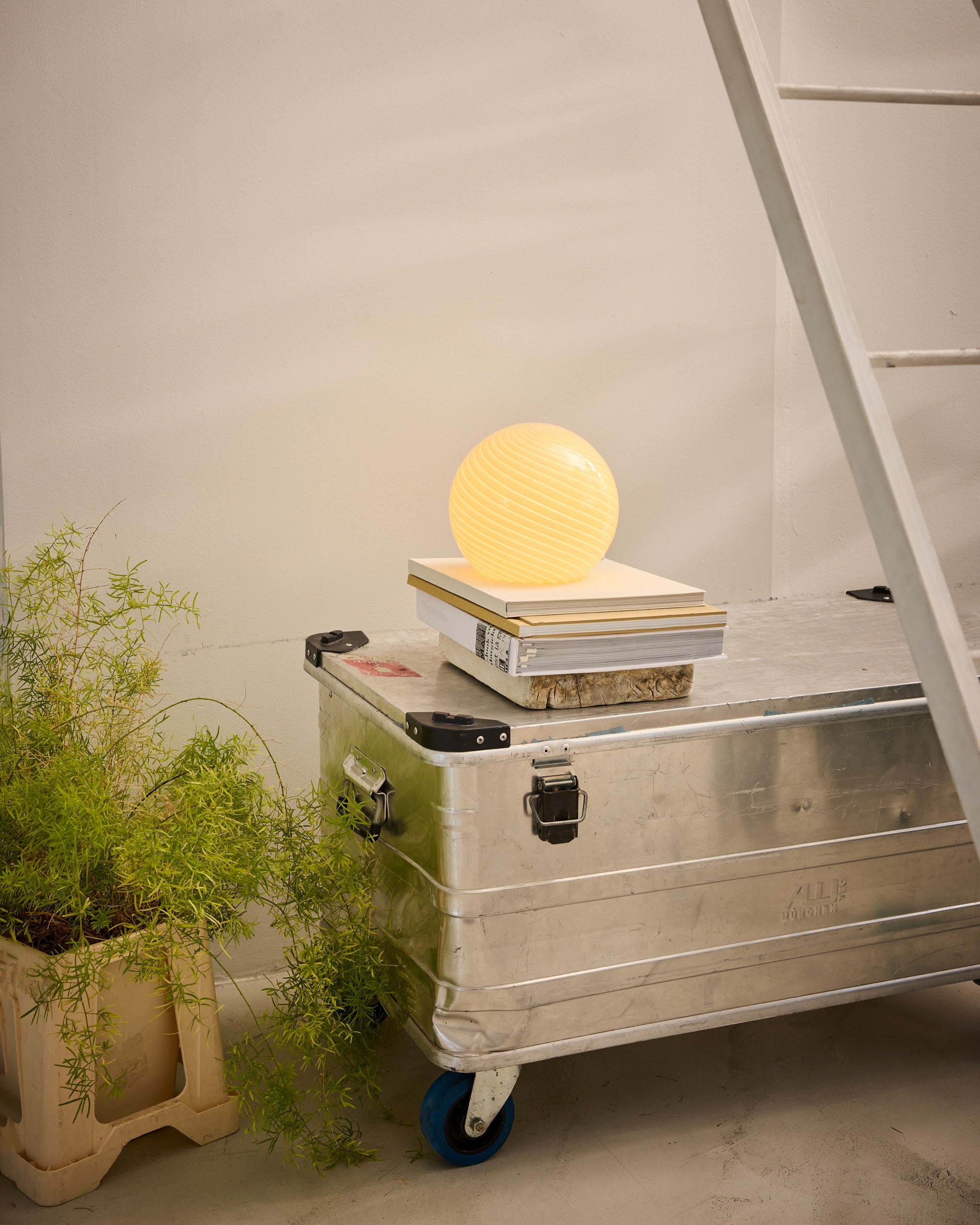 Candy Bordlampe Ø20 i Cream placeret på et par bøger for dens unikke design