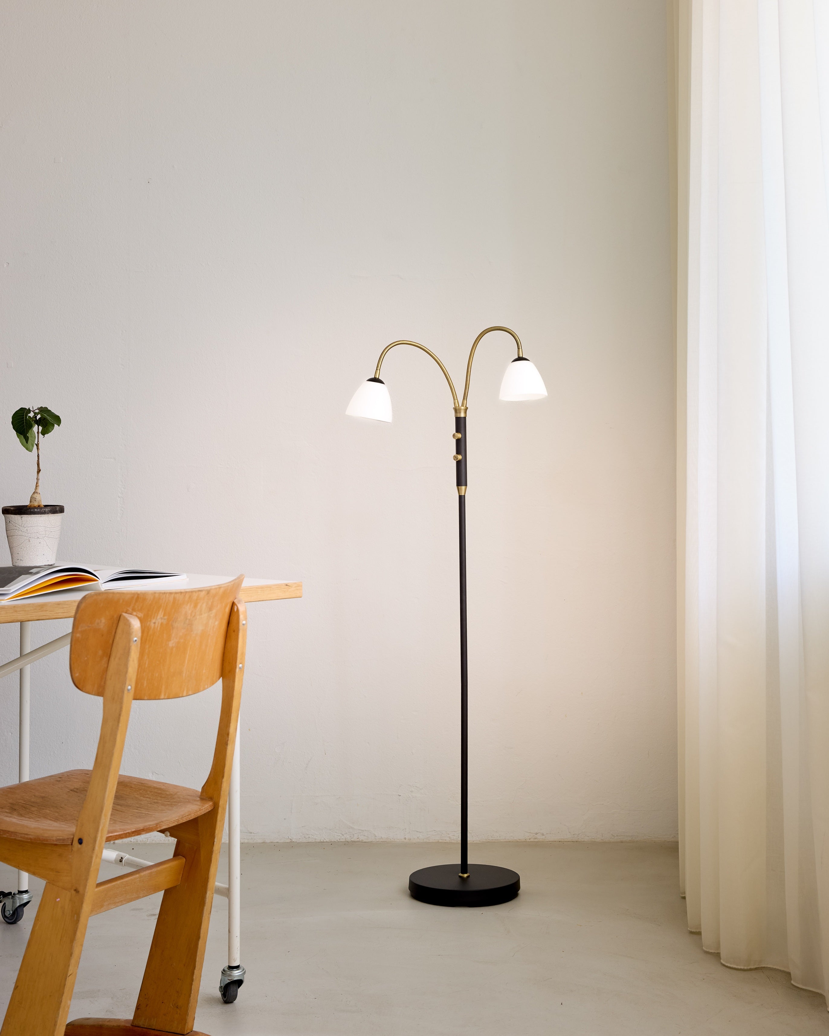 Den æstetiske Lucid LED 2-Arm Gulvlampe i Opal Antique placeret i stuen for dens behagelige og varme belysning i hele rummet