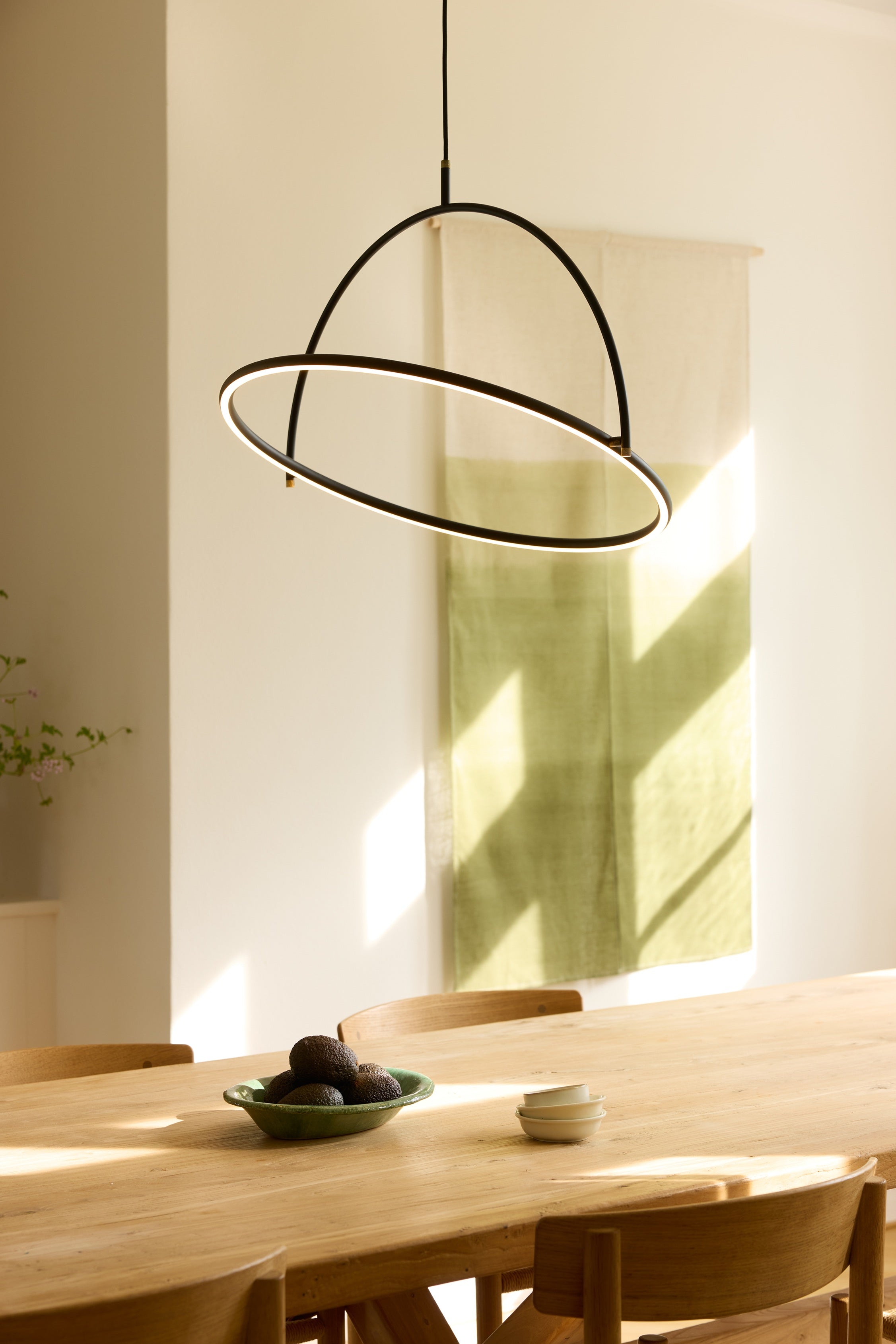 Zoomet helt ind på den unikke designet Tilt Lysekrone Ø60 3-Trins i Sort hængt op over spisebordet
