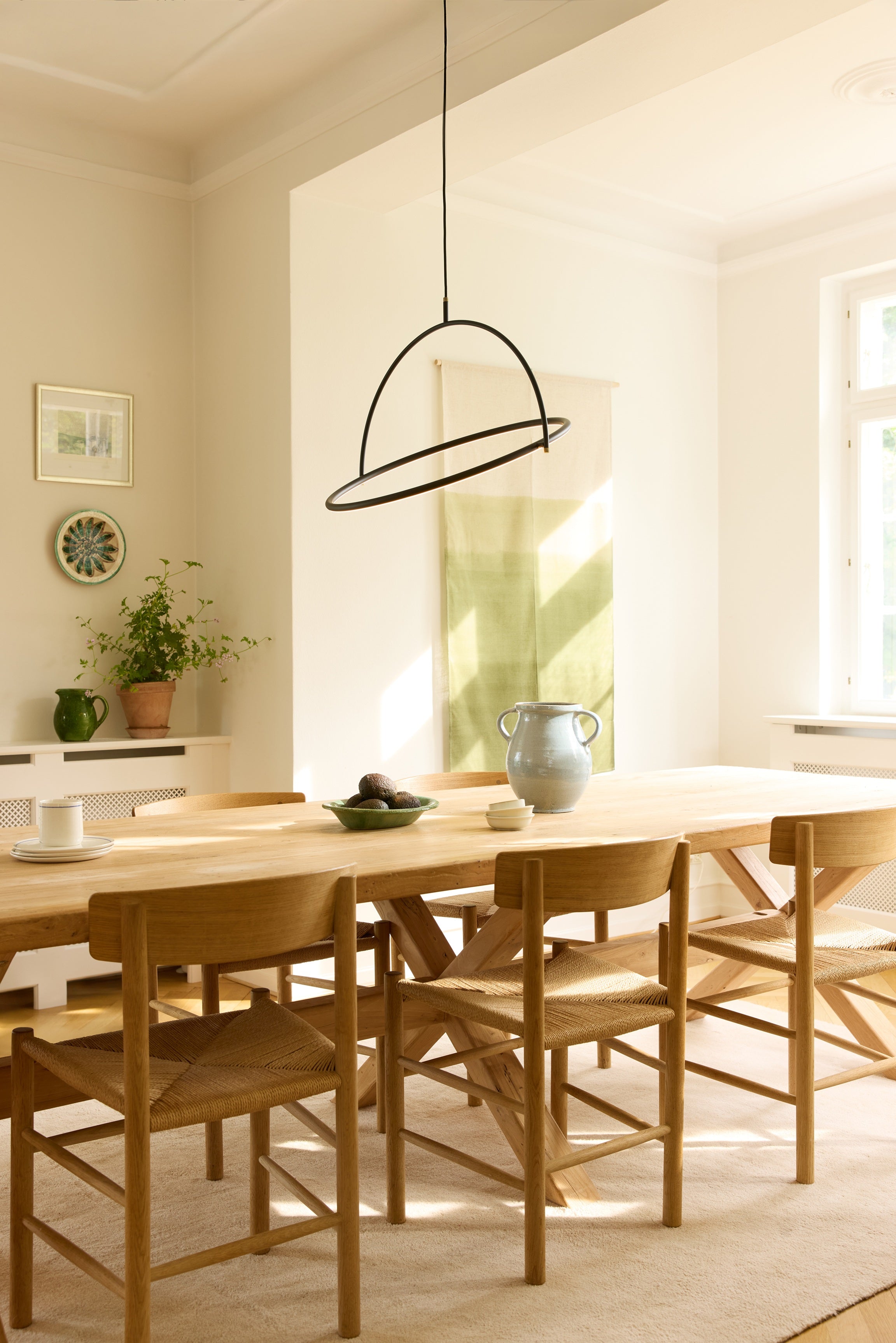 Den æstetiske Tilt Lysekrone Ø60 3-Trins i Sort hængt op over spisebordet i stuen for dens elegante og behagelige belysning