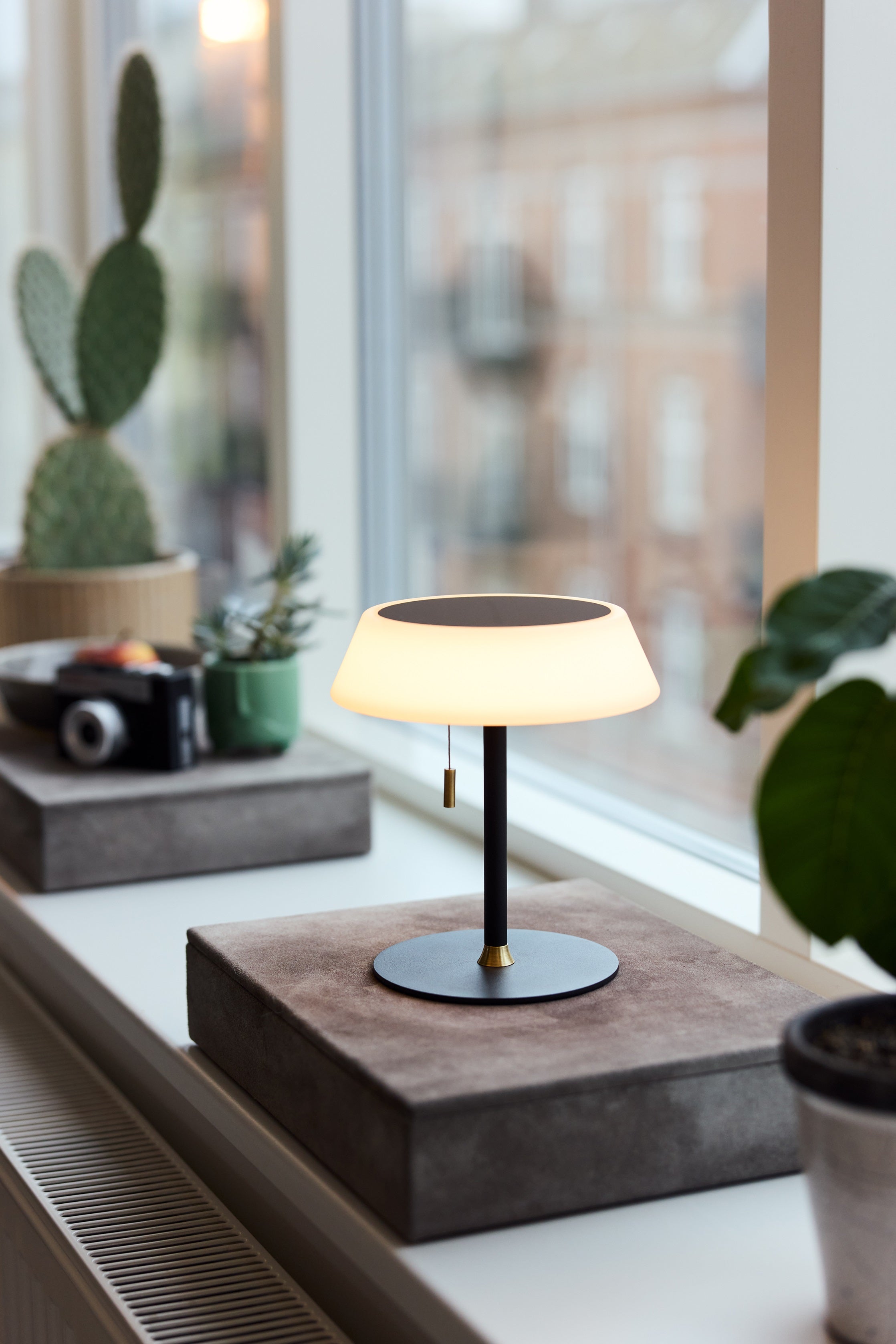 Halo Design Solar Portable Table Lamp i Sort i vindues kammen