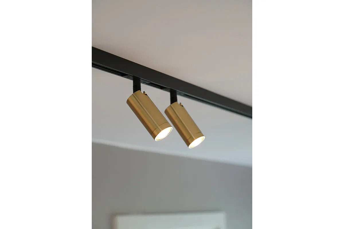 Den æstetiske Designline Domino Mini Spot i Guld hængt op i stuen for dens behagelige belysning