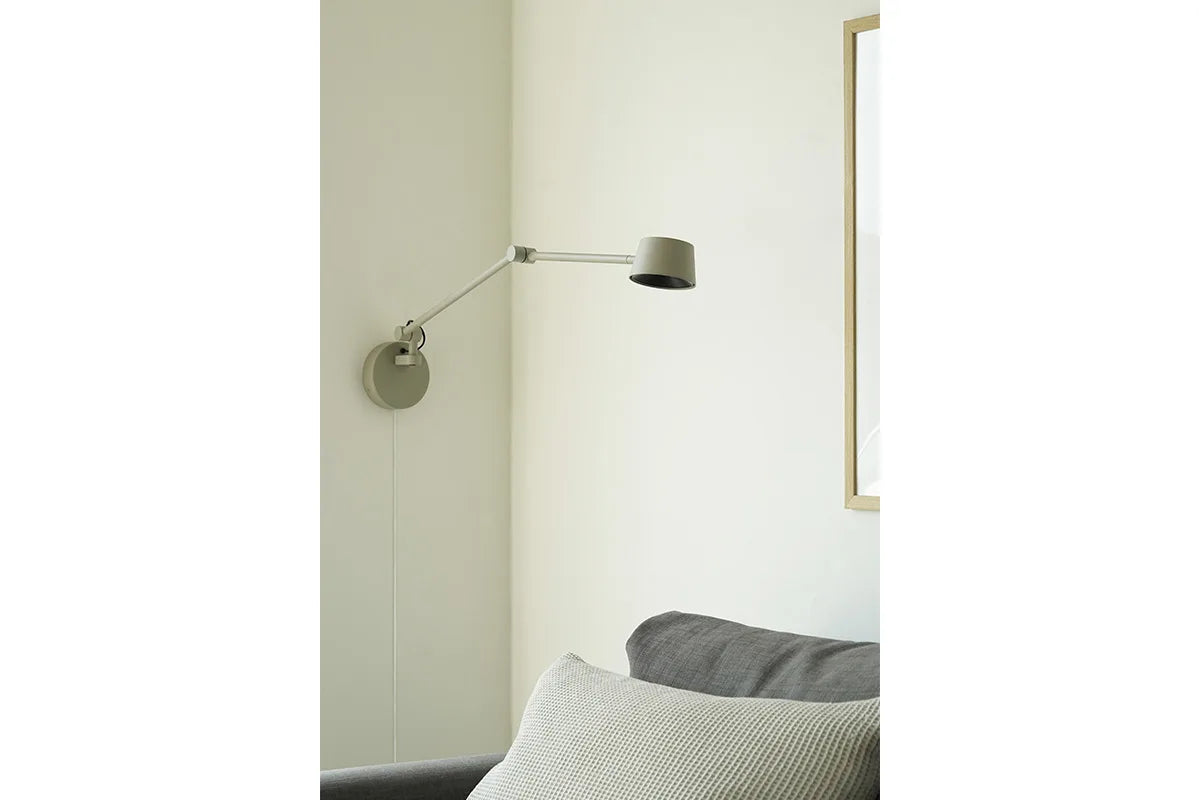 Direction Wall matgrå LED væglampe over sofaen i stuen
