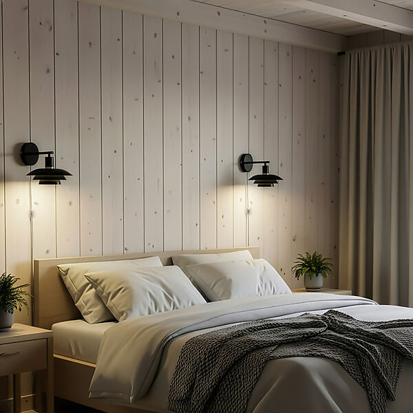 Den æstetiske Epsilon Væglampe i Sort hængt op ved sengekanten for deres varme belysning