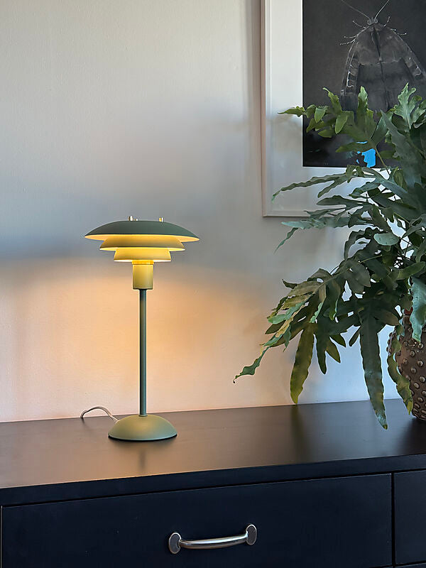 Den unikke designet Epsilon Bordlampe i Grøn placeret i stuen for dens behagelige belysning