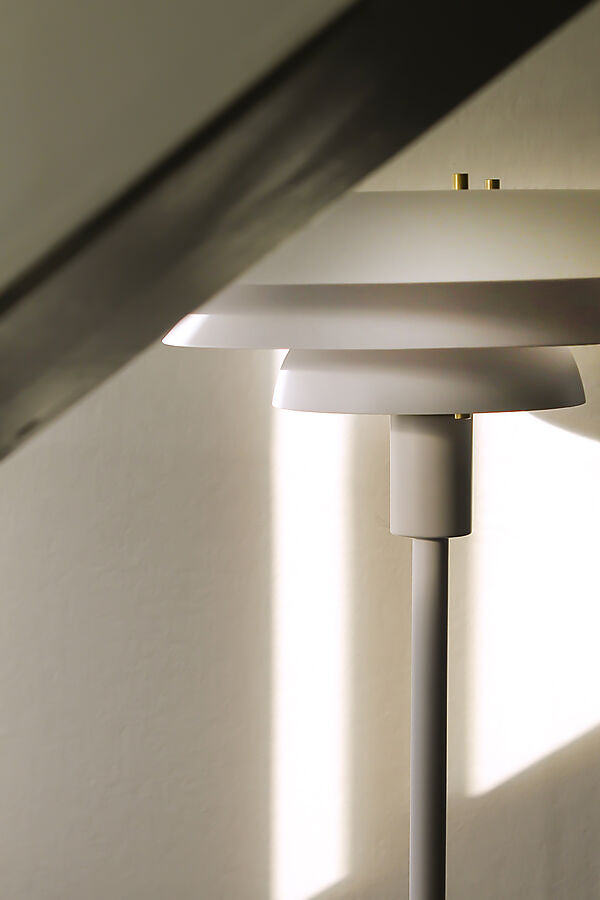 Zoomet helt ind på den unikke designet Epsilon Gulvlampe i Hvid placeret i hjørnet af stuen