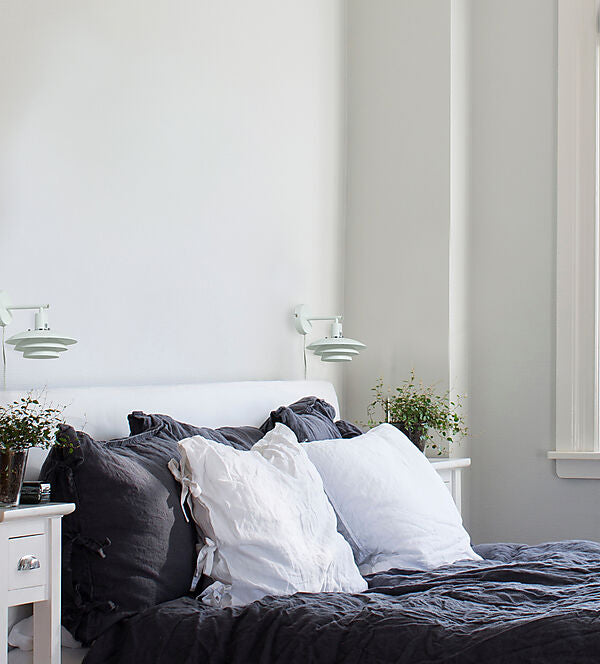 Den æstetiske Epsilon Væglampe i Hvid hængt op ved siden af sengen for dens behagelige belysning