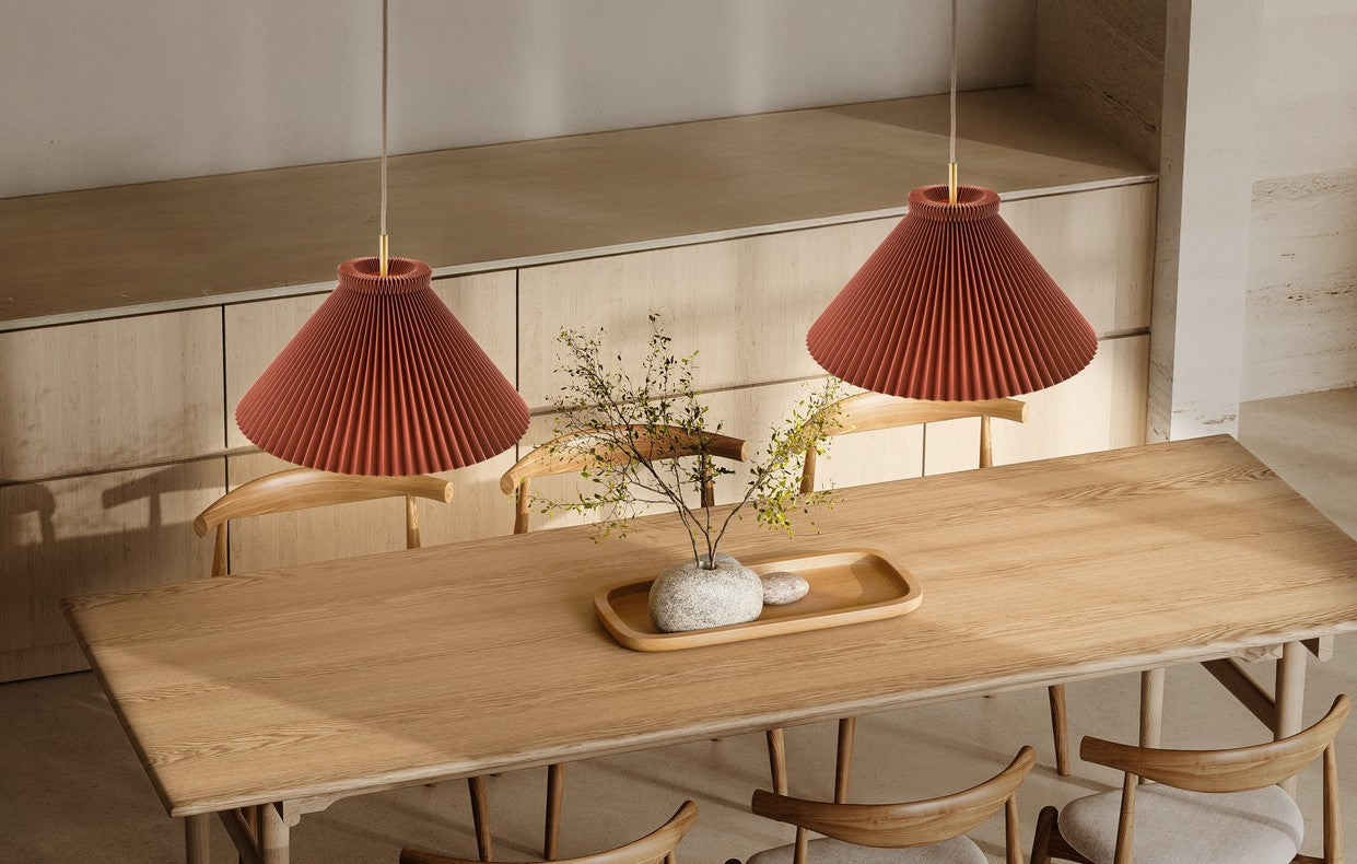 Den æstetiske Le Klint Colour Pleats 1-30 i Chocolate/Messing hængt op over spisebordet for dens behagelige belysning