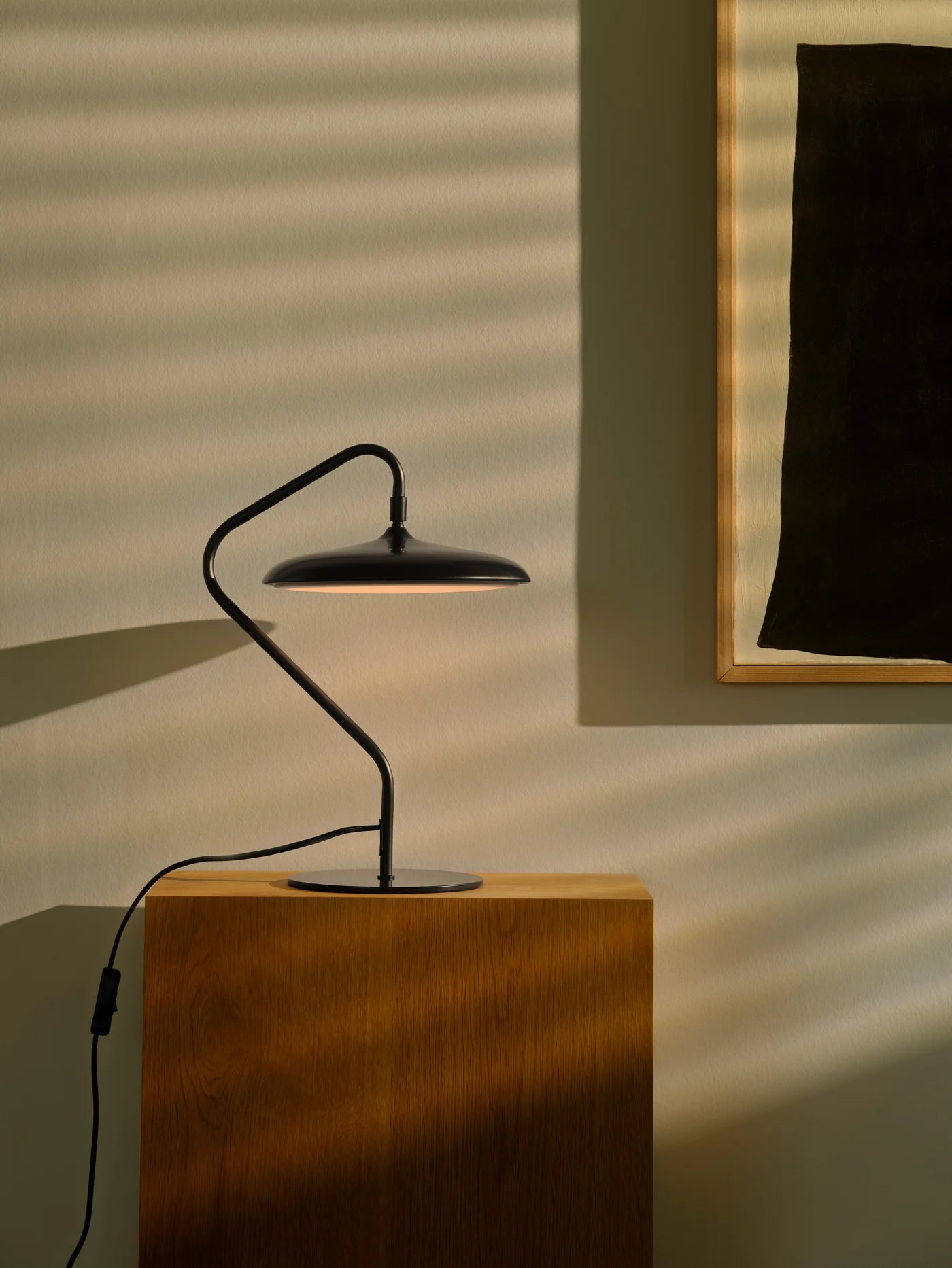 Nordlux Artist Bordlampe i Sort placeret på en hylde i stuen