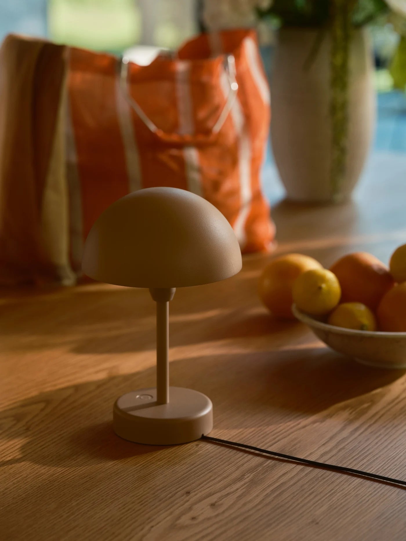 Den æstetiske Ellen To-Go Batterilampe i Brun til ladning i stuen