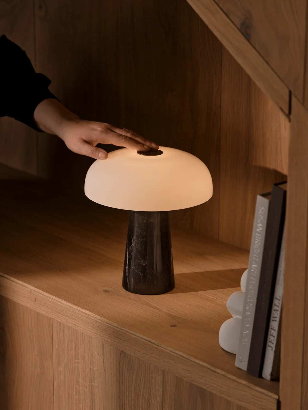 Glossy Mini Portable Bordlampe Sort bliver tændt på reol