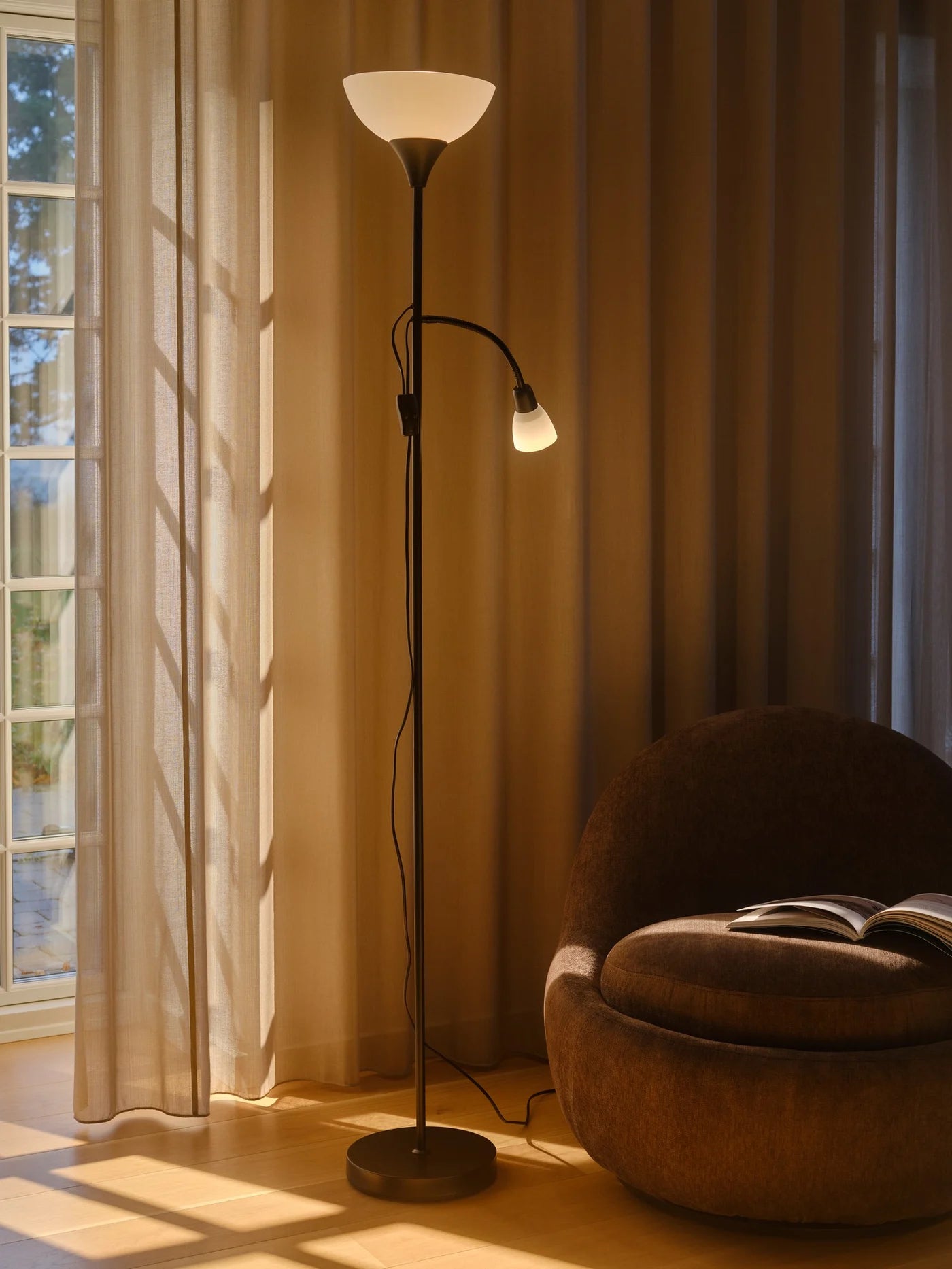 Nordlux Lauria Floor Lamp i Sort sat i hjørnet ved læsestolen