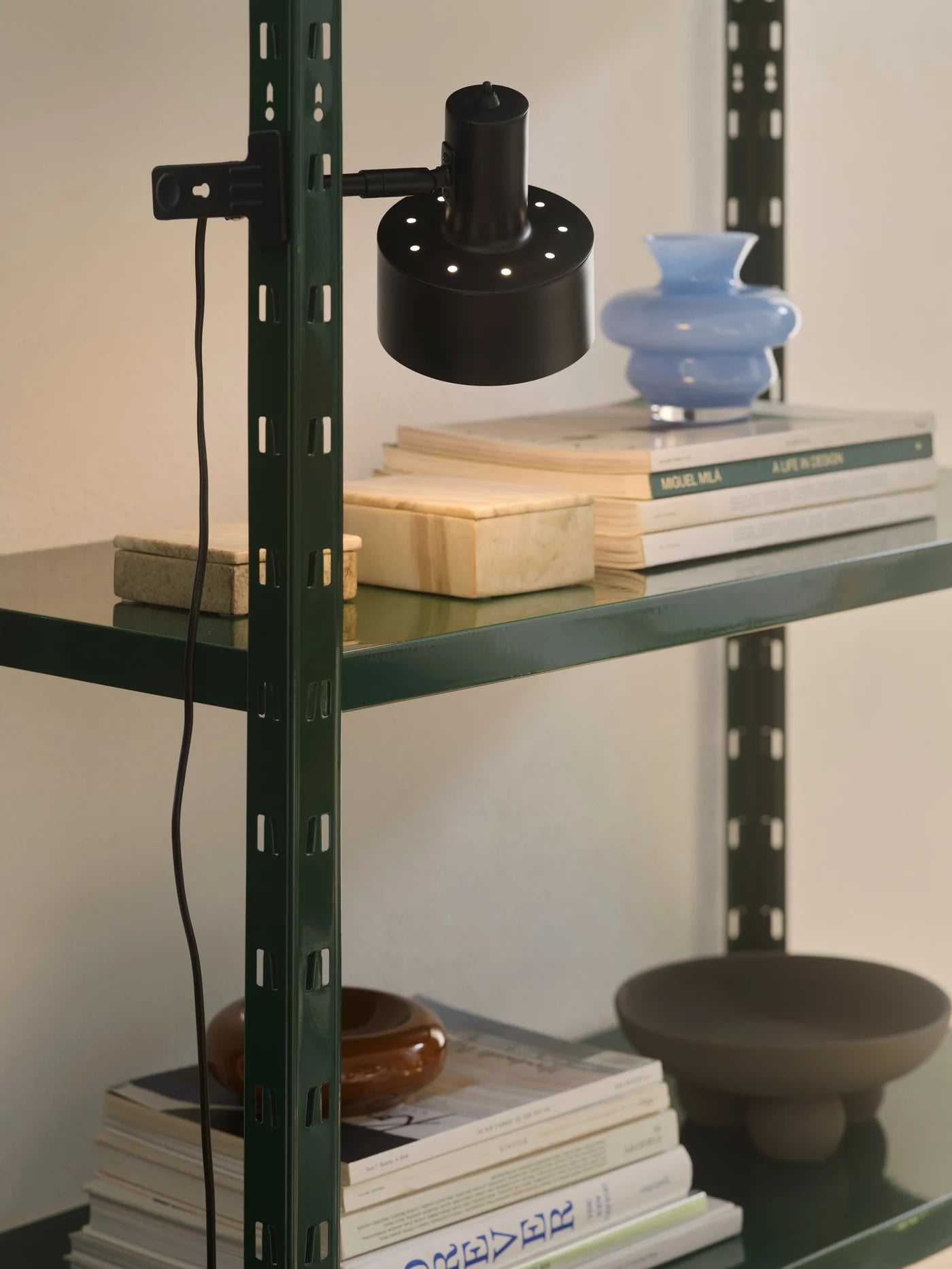Nordlux Matis Clamp Lamp i Sort ophængt på en hylde