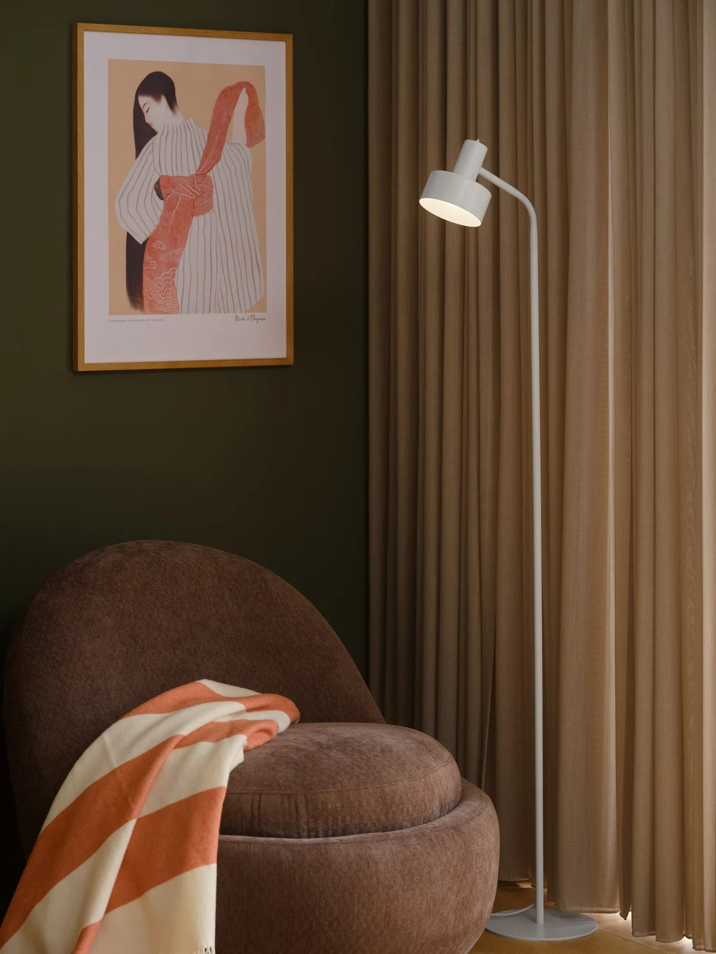 Nordlux Matis Floor Lamp i Hvid placeret ved siden af læsestolen i hjørnet for god belysning til klart at kunne læse
