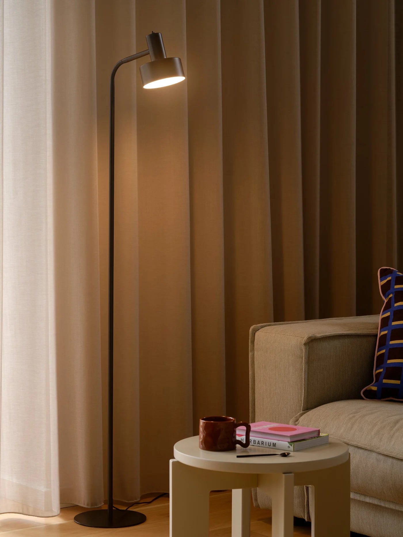 Nordlux Matis Floor Lamp i Sort placeret ved siden af sofaen