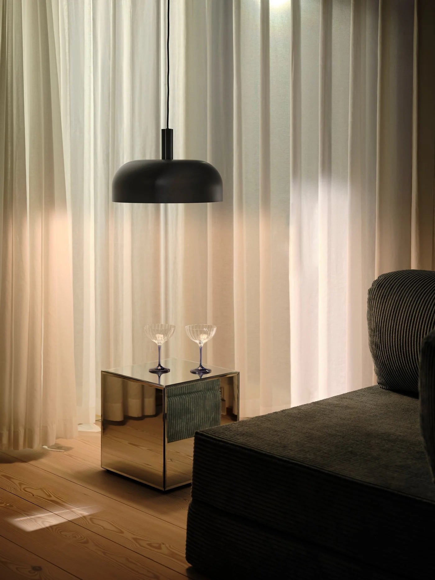Den elegante designet Sandro Pendel i Sort hængt op i stuen for dens behagelige belysning