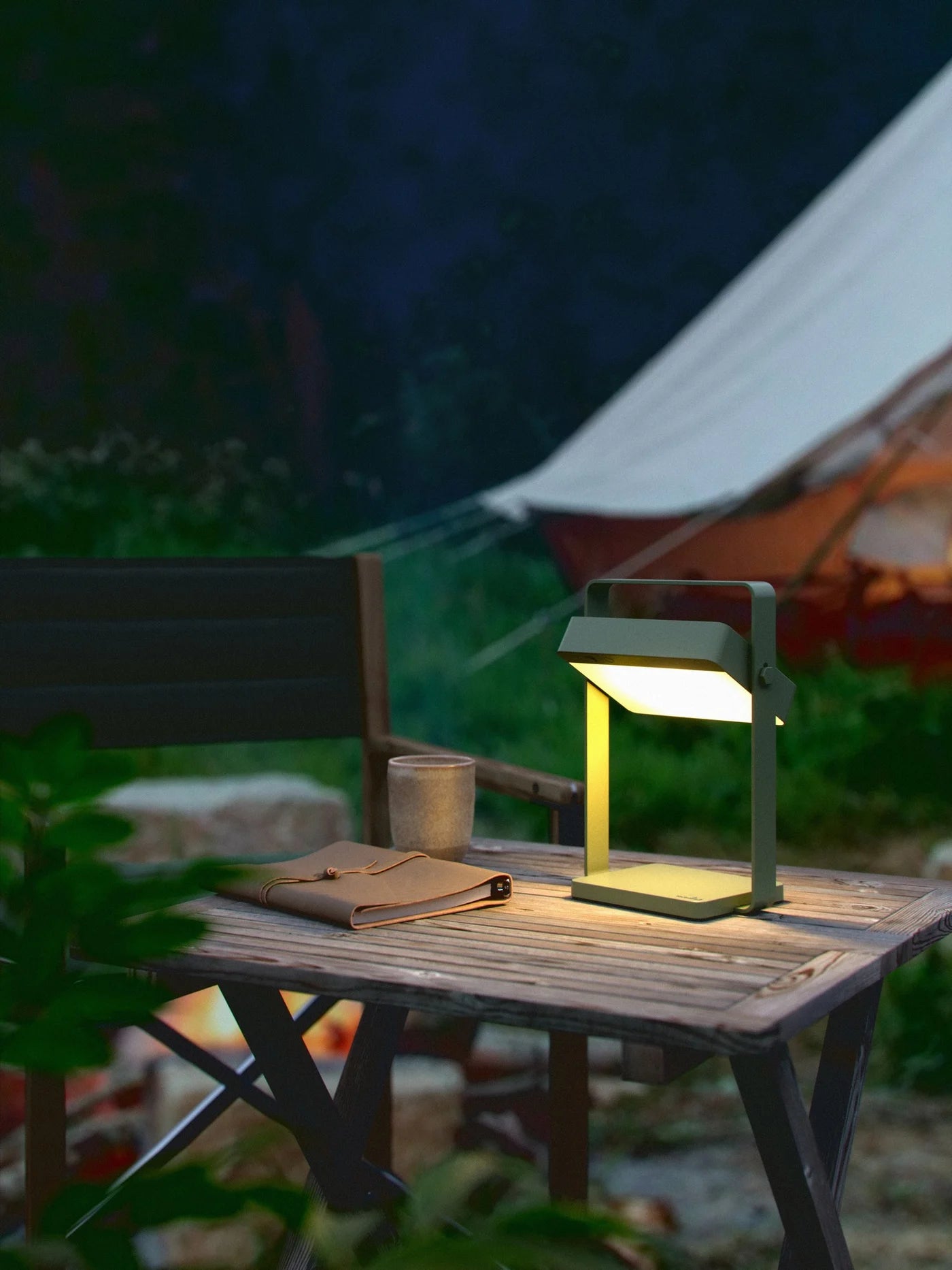 Nordlux Saulio Solar batterilampe i oliven grøn udendørs ved campingområde