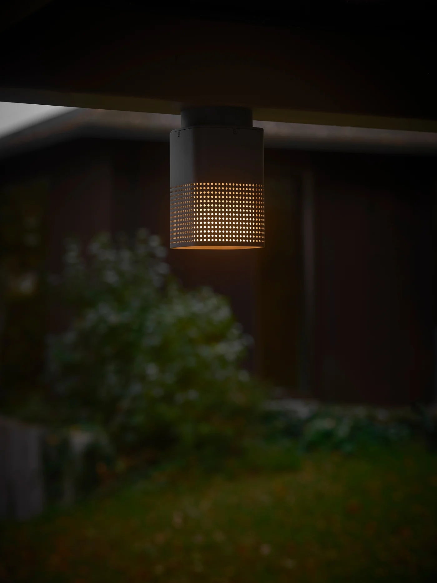 Den æstetiske Sidara Loftlampe i Seaside Antracit hængt op udenfor for dens varme belysning
