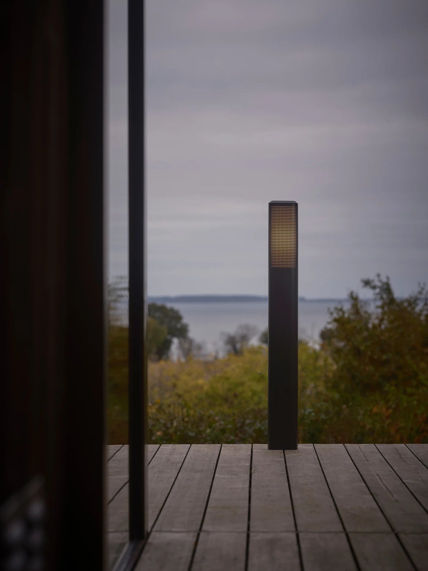 Den elegante designet Sidara 95 Havelampe Seaside i Sort placeret på terrassen for dens behagelige belysning