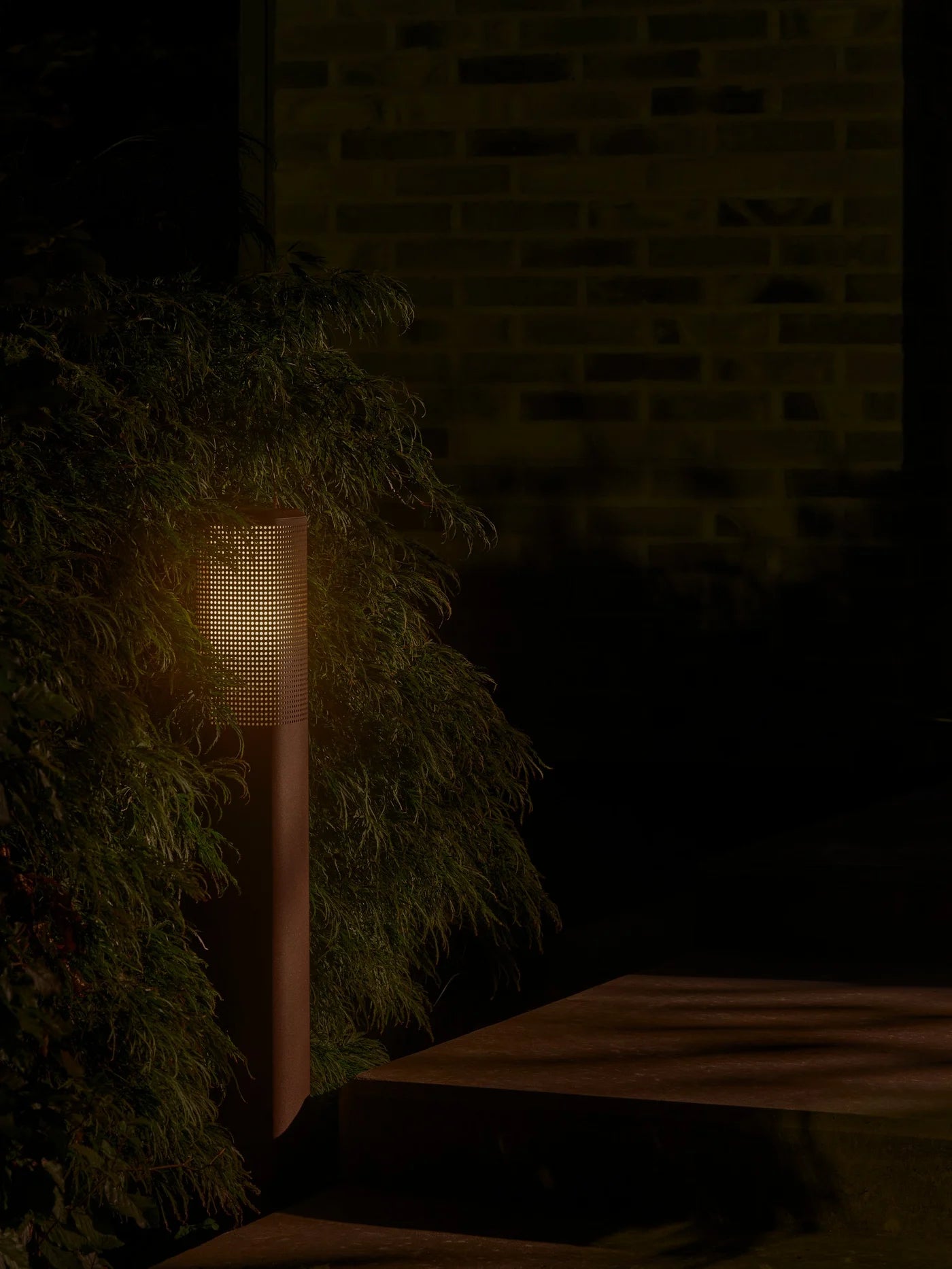 Den unikke designet Sidara 95 Havelampe Seaside i Metallisk Brun placeret på gå stien i haven for dens behagelige belysning