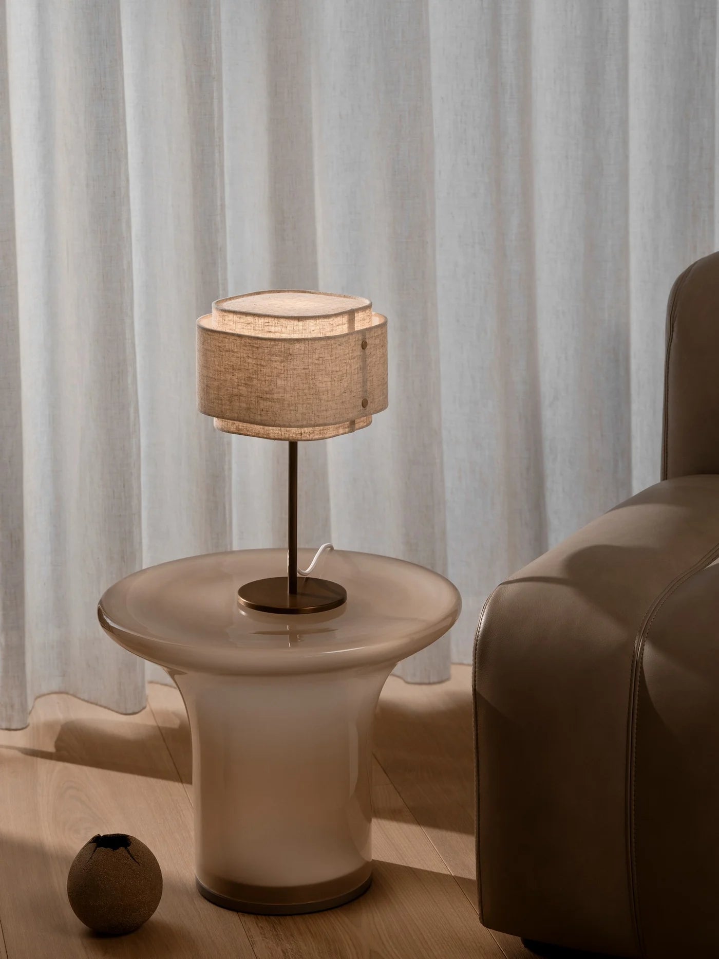 Den æstetiske Takai Bordlampe i Beige placeret i stuen for dens behagelige belysning
