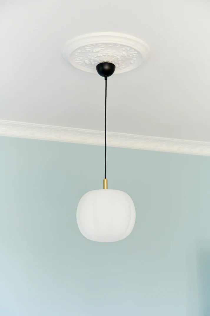Den æstetiske designet Pepo Medium Ø30 Pendel i Hvid/Messing hængt op i stuen for dens behagelige og varme belysning