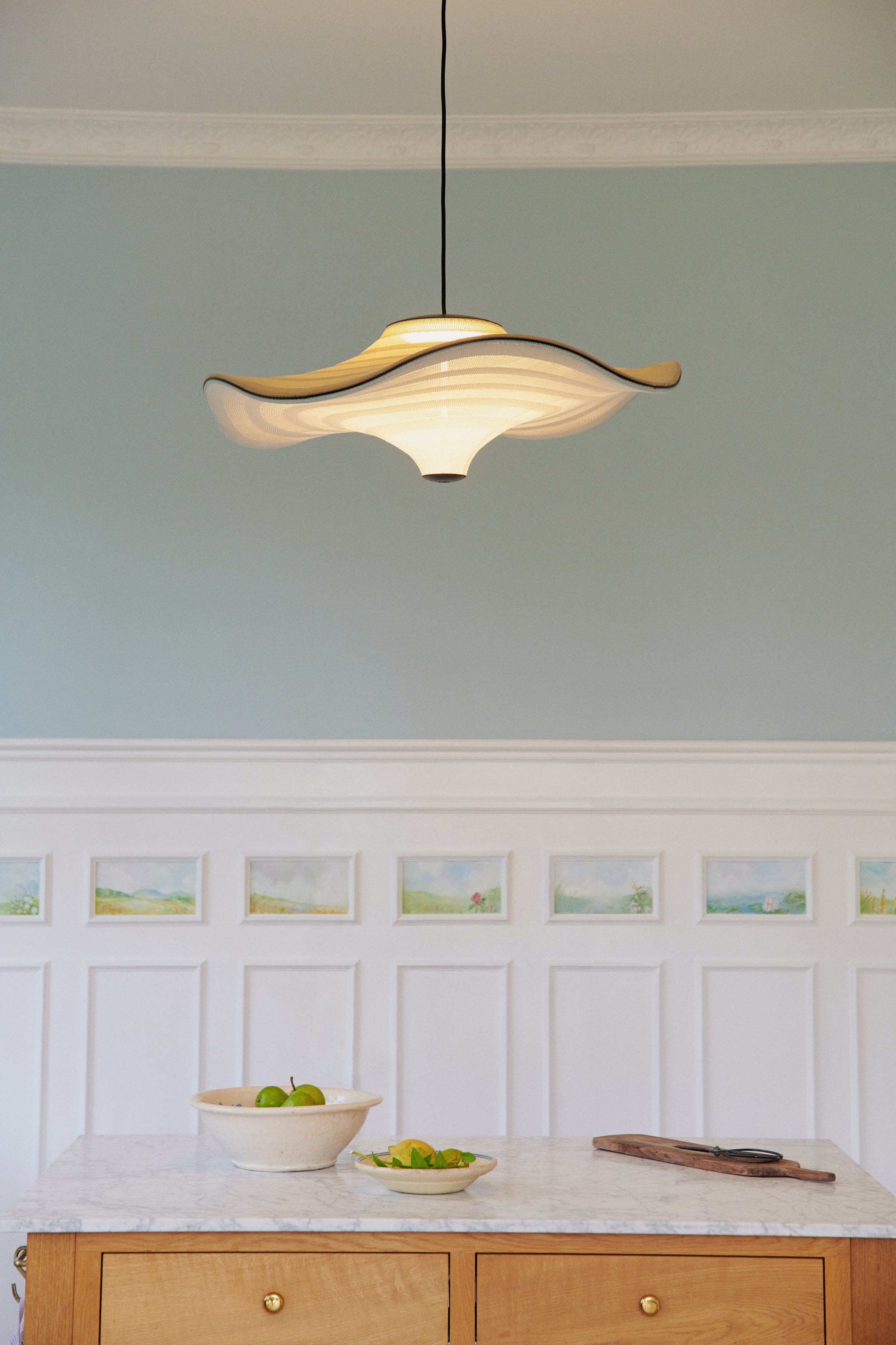 Den elegante Flying Ø96 i Light Terracotta hængt op i køkkenet og tændt for dens behagelige belysning
